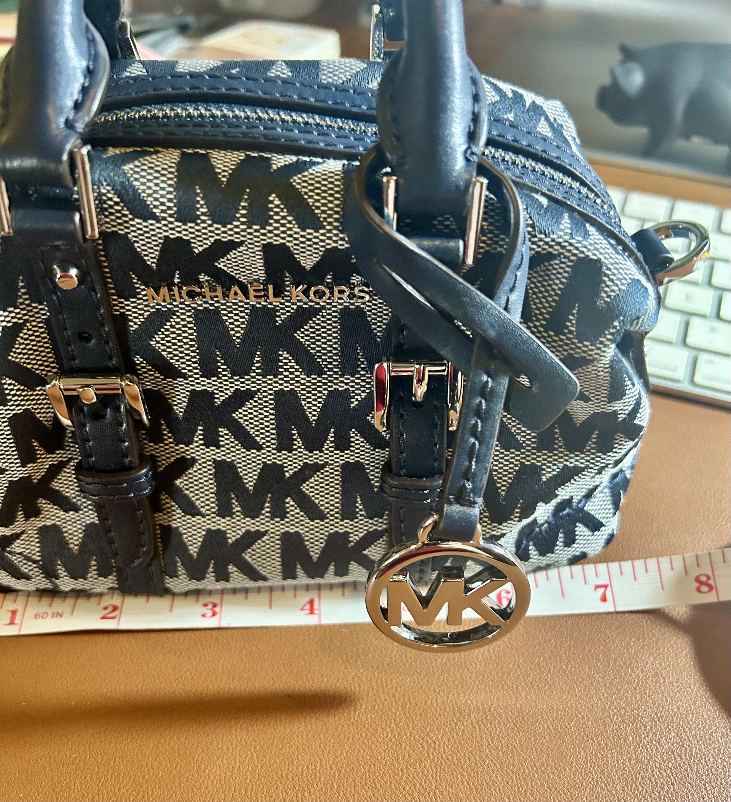Michael Kors ginger xs mini duffle bag (Category: Luxury Bags & Wallets) located in Quezon City. Submitted by asiaco (Listing ID 1419823581, Image 2). Description: For those who are keen on tiny things like me, this is an Authentic Michael Kors ginger xs mini duffle bag. Features a navy blue and gray MK logo pattern. Includes a detachable shoulder strap and a top handle. The bag has silver hardware and an MK charm. The original price tag is inclu