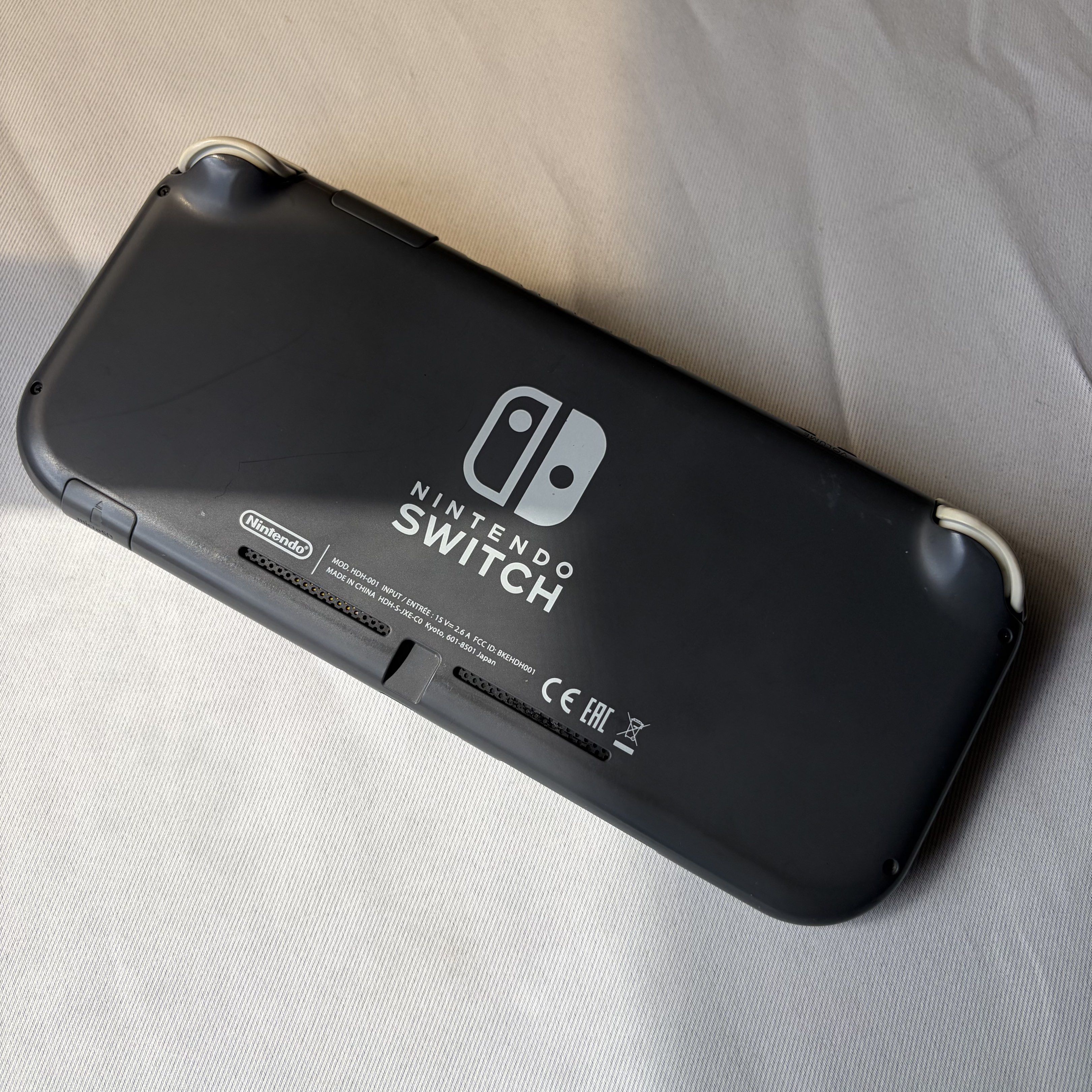 Nintendo Switch Lite Dark Gray [DEFECTIVE] (Category: Nintendo) located in Taguig. Submitted by 2hand927483 (Listing ID 1419845798, Image 2). Description: Nintendo Switch Lite Dark Gray [DEFECTIVE] DEFECTIVE UNIT ONLY! - The unit does not come with a charger KNOWN ISSUES: - The unit does not turn on - The unit was previously modded but the modchip was removed - Discolored buttons and joysticks - Crack on the upper right side of the unit (near the