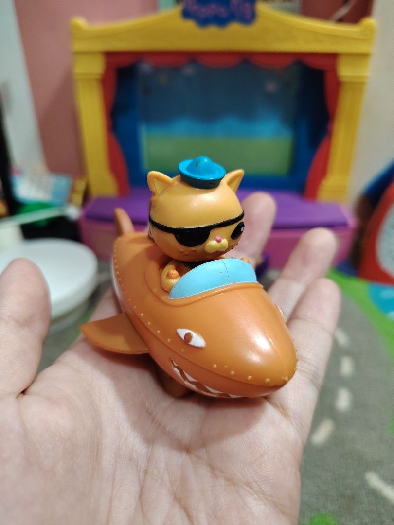 Octonauts Cat in Shark Plane Toy (Category: Kids Toys) located in Iligan City. Submitted by shehabdor98515 (Listing ID 1419852004, Image 1). Description: - Octonauts toy featuring a cat character. - Comes in an orange shark-shaped plane. - Cat character has a blue hat and sunglasses. - Plane has fins and a cockpit. - Small, handheld size. - Detailed design. - Perfect for imaginative play..