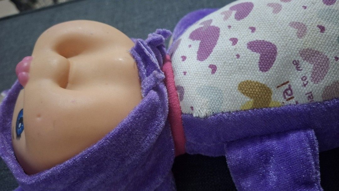 Original Cabbage patch Purple Baby Doll (Category: Plushies & Soft Toys) located in Quezon City. Submitted by _helpmedeclutter (Listing ID 1419899524, Image 2). Description: - Adorable plush baby doll - Dressed in a purple outfit - Soft body with patterned back - Sleeping face with closed eyes and pink nose - Purple arms and legs.
