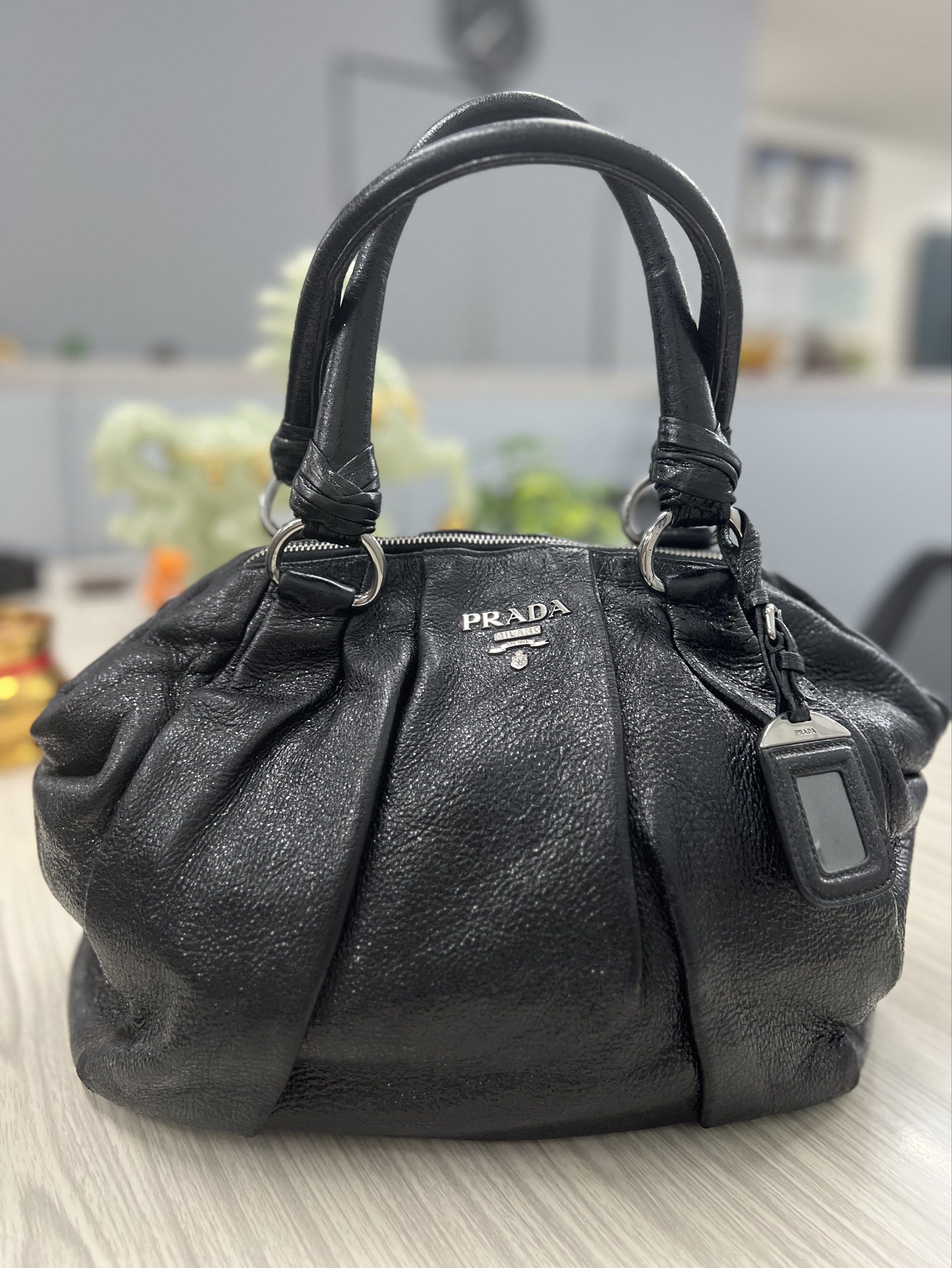 Prada Black Vitello Daino Leather Handbag (Category: Luxury Bags & Wallets) located in Cagayan de Oro. Submitted by riggstuffs (Listing ID 1419891823, Image 1). Description: ➡️ Guaranteed Authentic Prada Vitello Daino Handbag ➡️ With white tag ➡️ Exterior and interior areas are in good condition ➡️ No long sling ➡️ Dimension: H12”x L 17”, Handle drop 7” Disclaimer: Riggstuffs is not associated or affiliated with the brand posted. All copyrights a