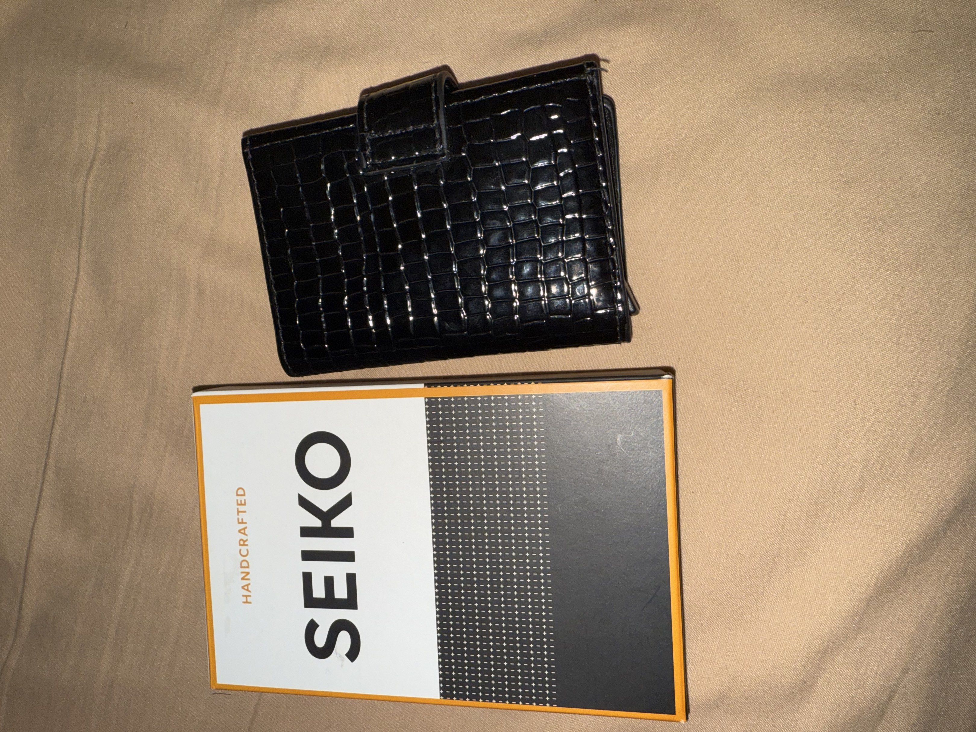 Seiko Card Holder Wallet (Category: Luxury Bags & Wallets) located in Pasig City. Submitted by cads.123 (Listing ID 1419838477, Image 3). Description: - Seiko black wallet - Crocodile skin pattern - Snap closure - Multiple card slots - Clear ID window - Additional compartments - Seiko logo inside - Comes with original box.