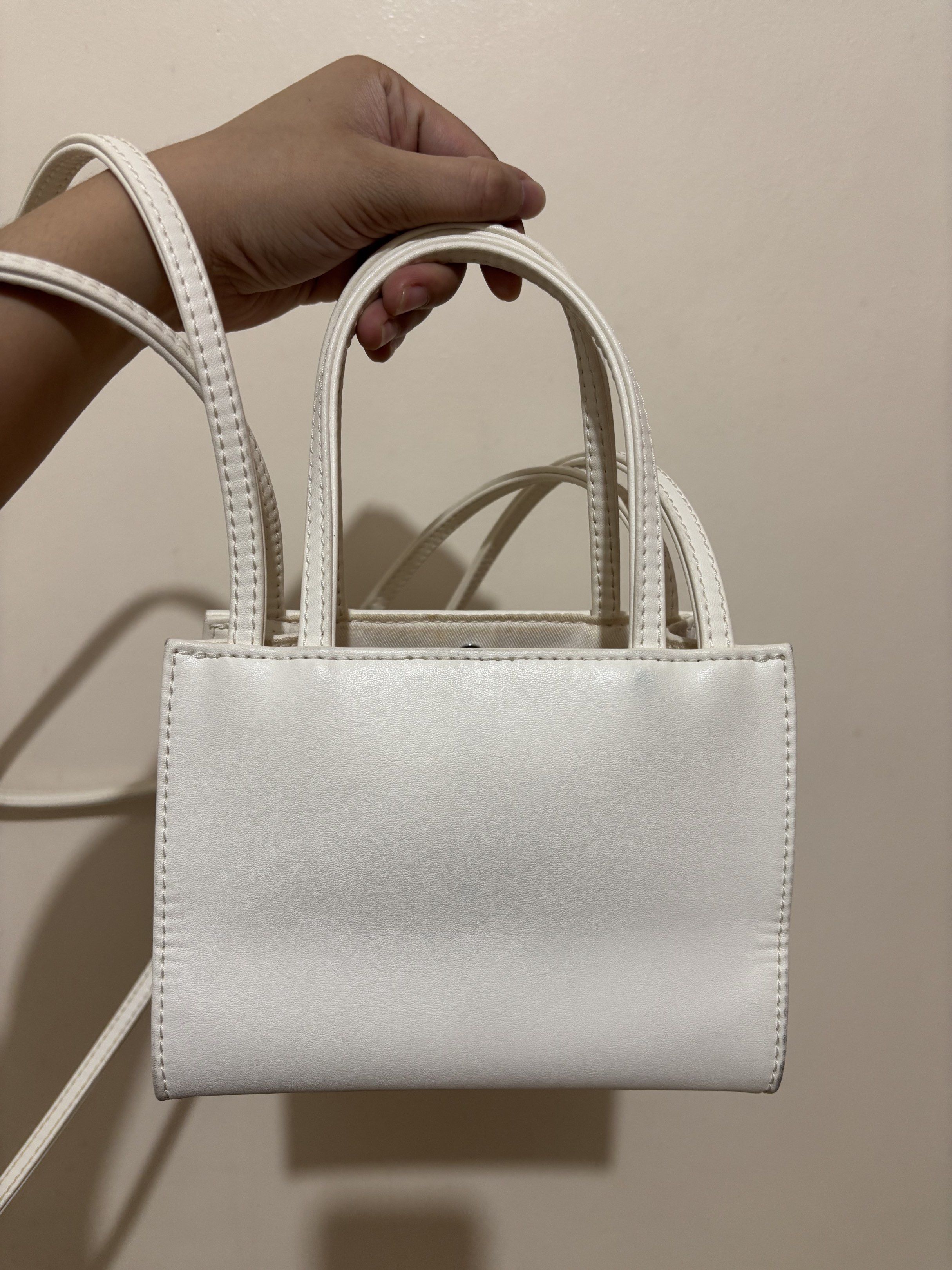 Telfar Shopping Bag Small White (Category: Luxury Bags & Wallets) located in Cainta. Submitted by cara00 (Listing ID 1419781142, Image 2). Description: Telfar Shopping Bag Small White Features: - Top handle - Crossbody strap Includes: - Dust bag - Tag - Plastic bag Issues: - Signs of usage - Minor mark present.