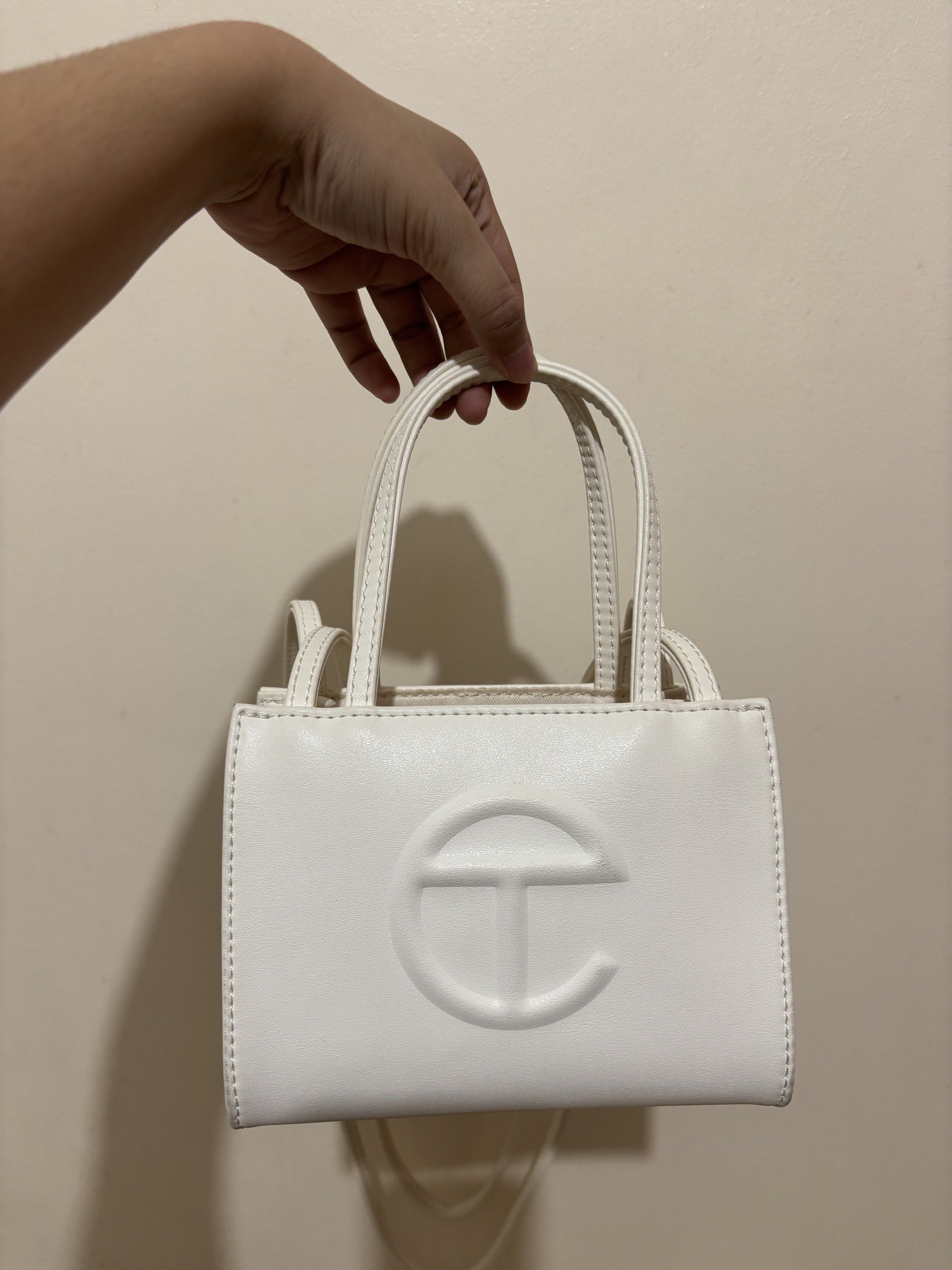 Telfar Shopping Bag Small White (Category: Luxury Bags & Wallets) located in Cainta. Submitted by cara00 (Listing ID 1419781142, Image 1). Description: Telfar Shopping Bag Small White Features: - Top handle - Crossbody strap Includes: - Dust bag - Tag - Plastic bag Issues: - Signs of usage - Minor mark present.