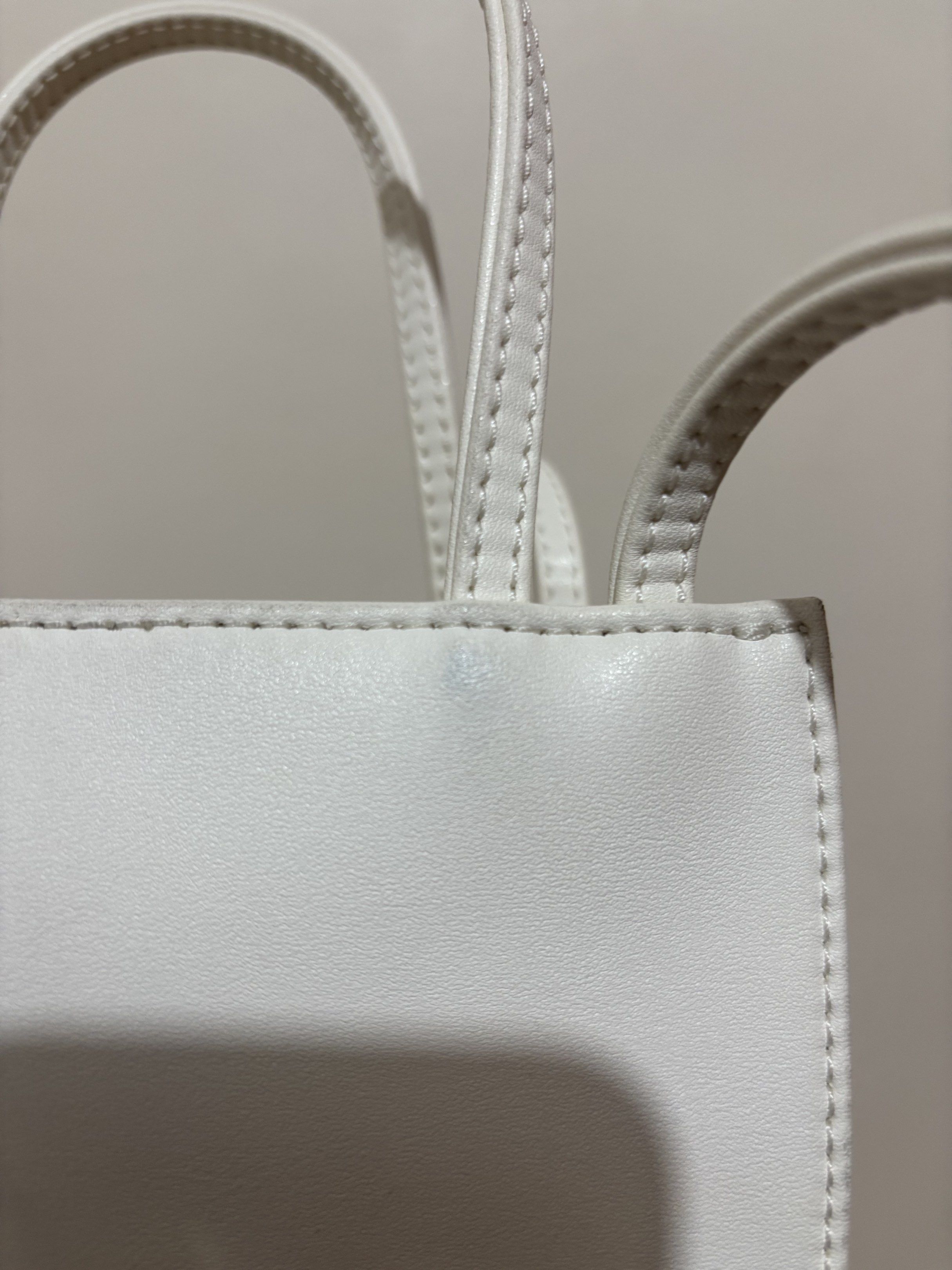 Telfar Shopping Bag Small White (Category: Luxury Bags & Wallets) located in Cainta. Submitted by cara00 (Listing ID 1419781142, Image 3). Description: Telfar Shopping Bag Small White Features: - Top handle - Crossbody strap Includes: - Dust bag - Tag - Plastic bag Issues: - Signs of usage - Minor mark present.