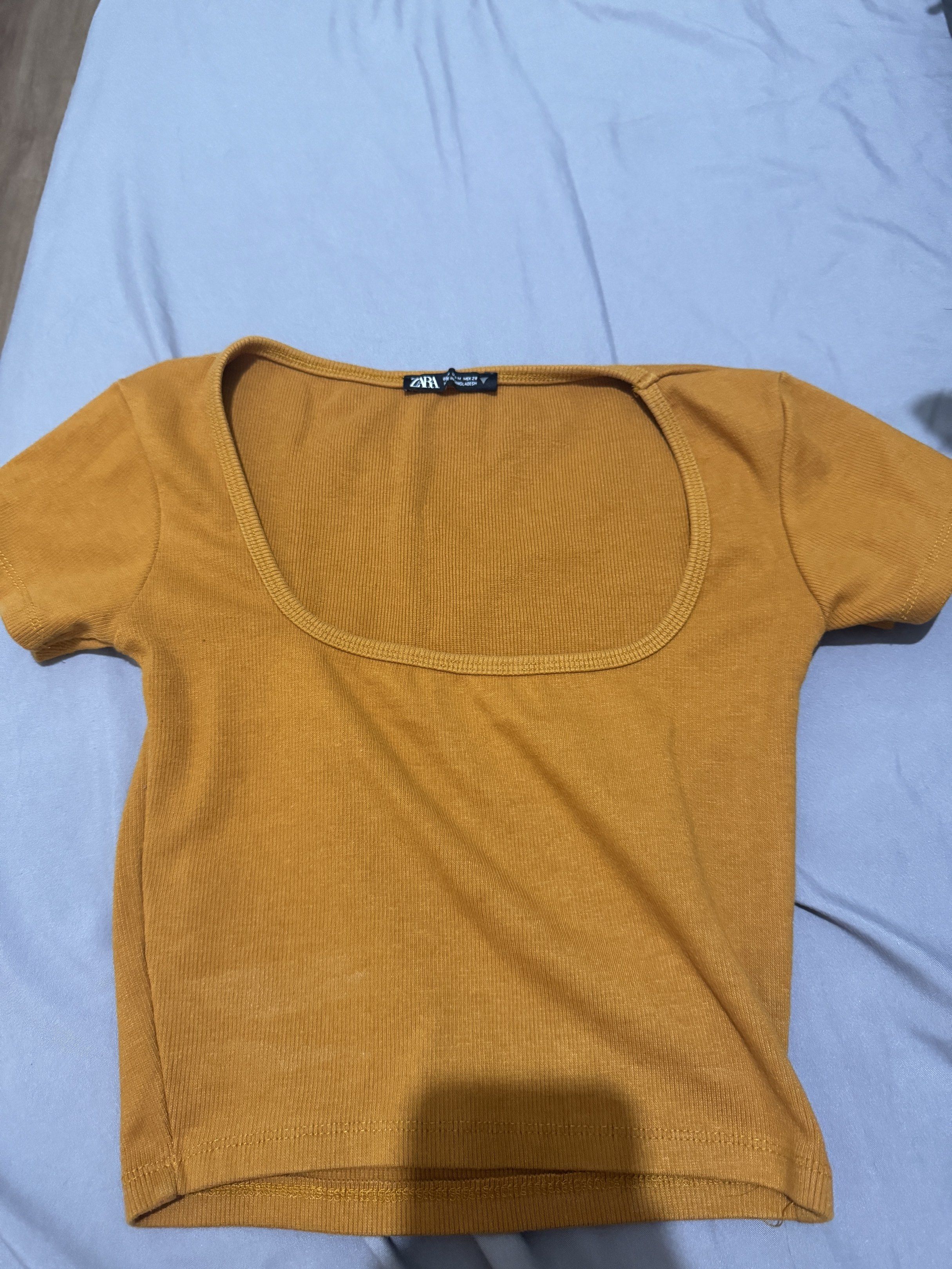 Zara Square Neck Crop Top (Category: Sleeveless) located in Pasig City. Submitted by caaex (Listing ID 1419940791, Image 1). Description: - Zara mustard yellow crop top - Size: M - Features a square neckline - Short sleeves - Ribbed fabric - Made in Bangladesh - Versatile for various occasions.