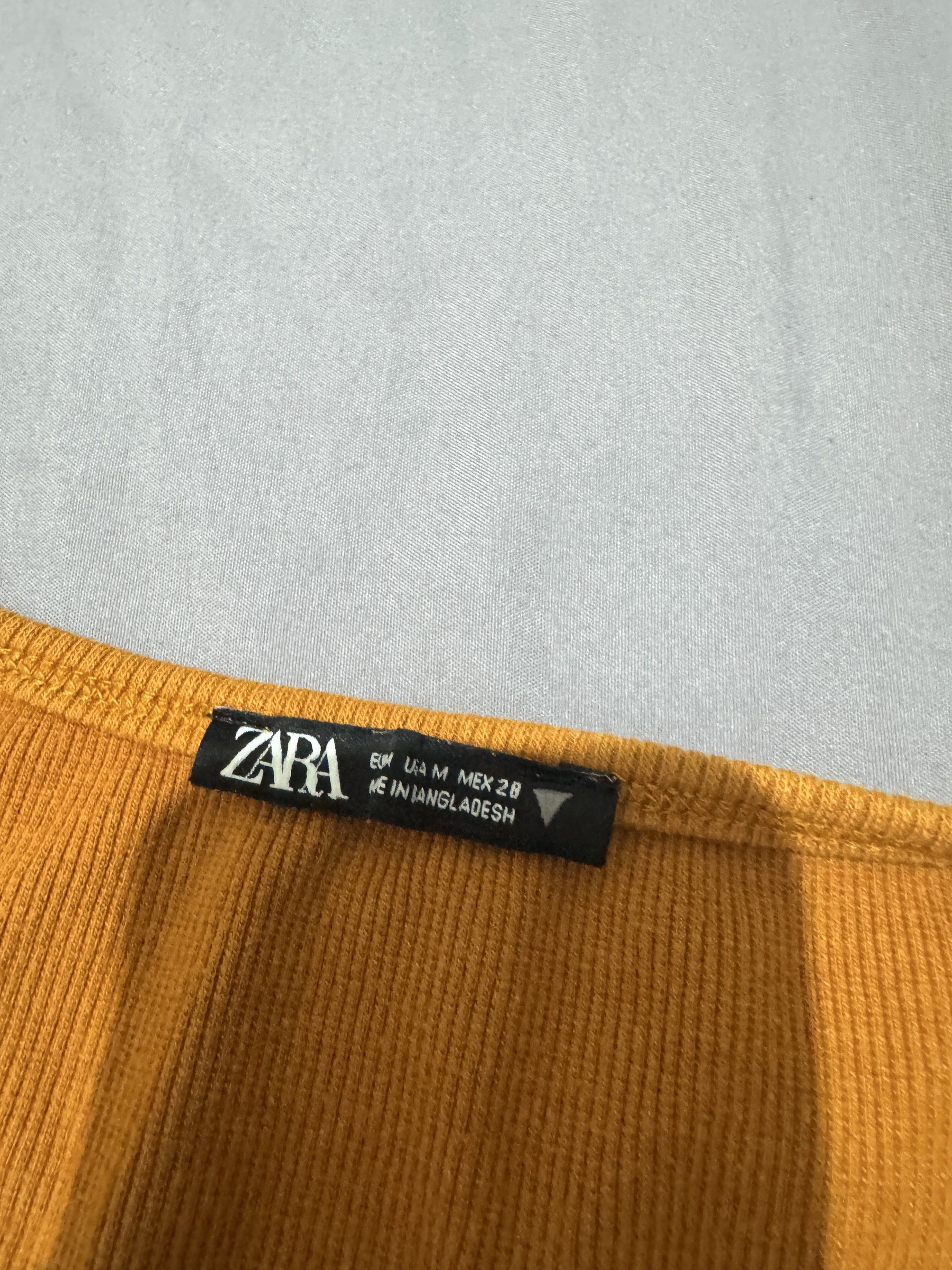 Zara Square Neck Crop Top (Category: Sleeveless) located in Pasig City. Submitted by caaex (Listing ID 1419940791, Image 2). Description: - Zara mustard yellow crop top - Size: M - Features a square neckline - Short sleeves - Ribbed fabric - Made in Bangladesh - Versatile for various occasions.