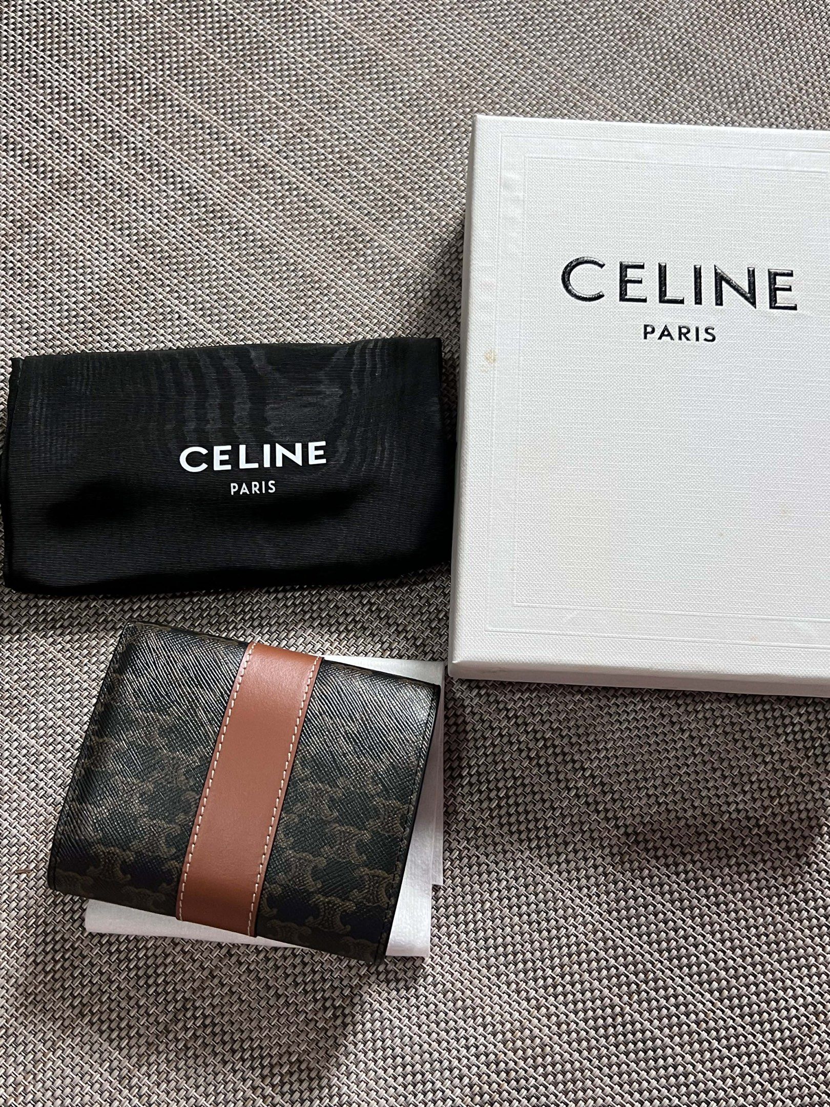 Celine Triomphe Bi-Fold Wallet (Category: Luxury Bags & Wallets) located in Manila. Submitted by luxurytreasure.ph (Listing ID 1420046595, Image 2). Description: - Celine Triomphe bi-fold wallet - Features signature Triomphe canvas - Brown leather stripe detail - Includes original box and dust bag - Made in Italy - Brown leather interior with card slots.