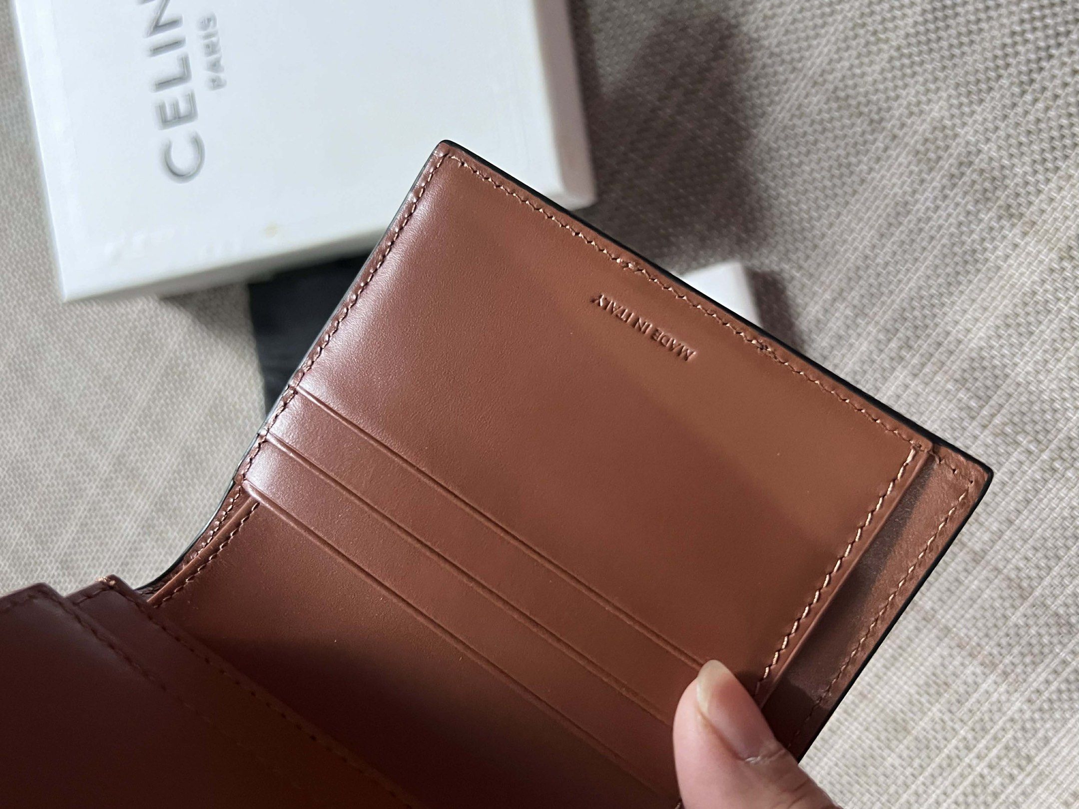 Celine Triomphe Bi-Fold Wallet (Category: Luxury Bags & Wallets) located in Manila. Submitted by luxurytreasure.ph (Listing ID 1420046595, Image 3). Description: - Celine Triomphe bi-fold wallet - Features signature Triomphe canvas - Brown leather stripe detail - Includes original box and dust bag - Made in Italy - Brown leather interior with card slots.