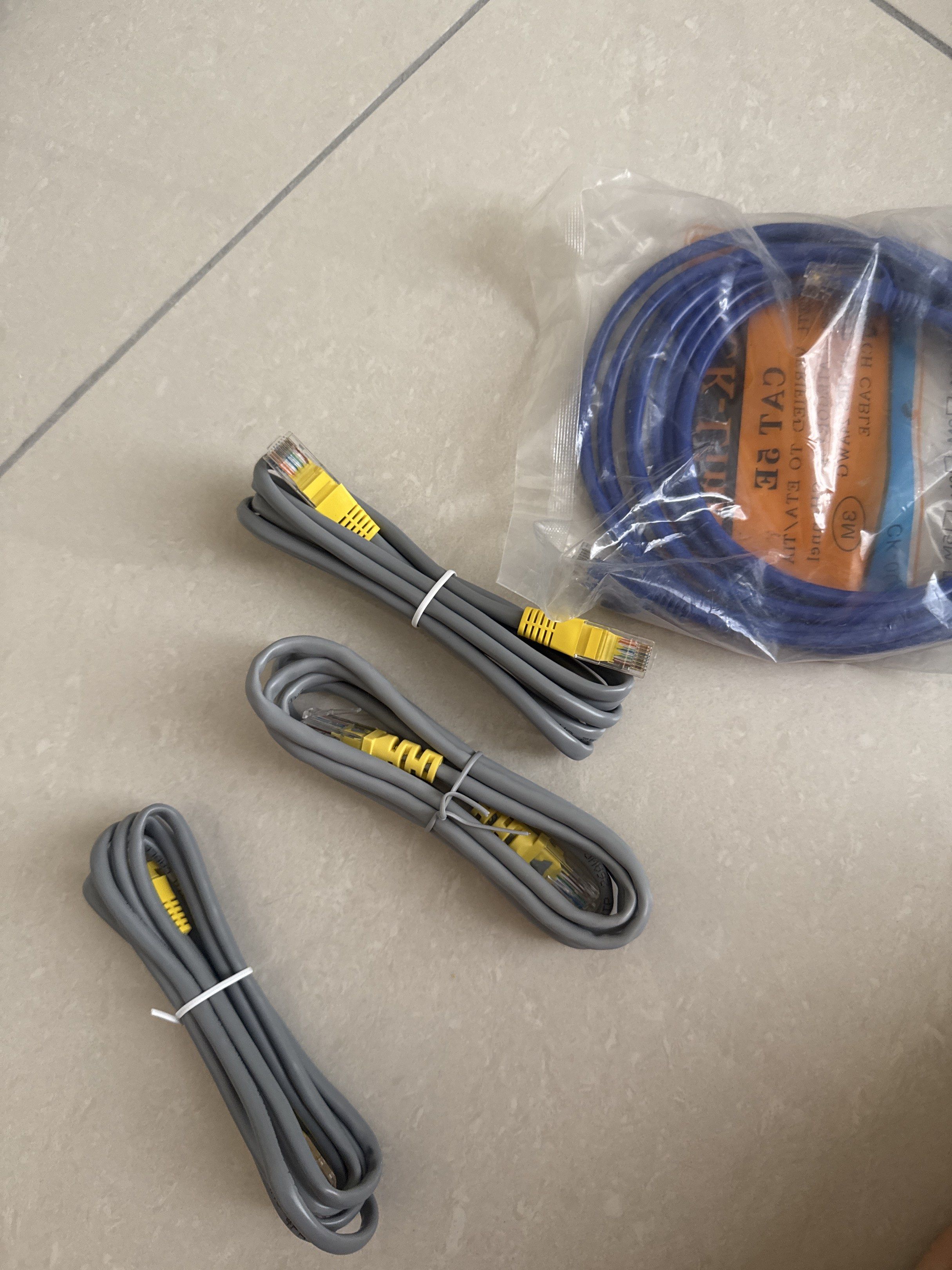 Network Cables (Category: Networking) located in Kuala Lumpur. Submitted by sheirlytan (Listing ID 1420023976, Image 2). Description: - CK-Link CAT 5E network cable set - Includes: - Three grey cables (bundled with cable ties, lengths not specified) - One blue cable (3 meters, new in original packaging).