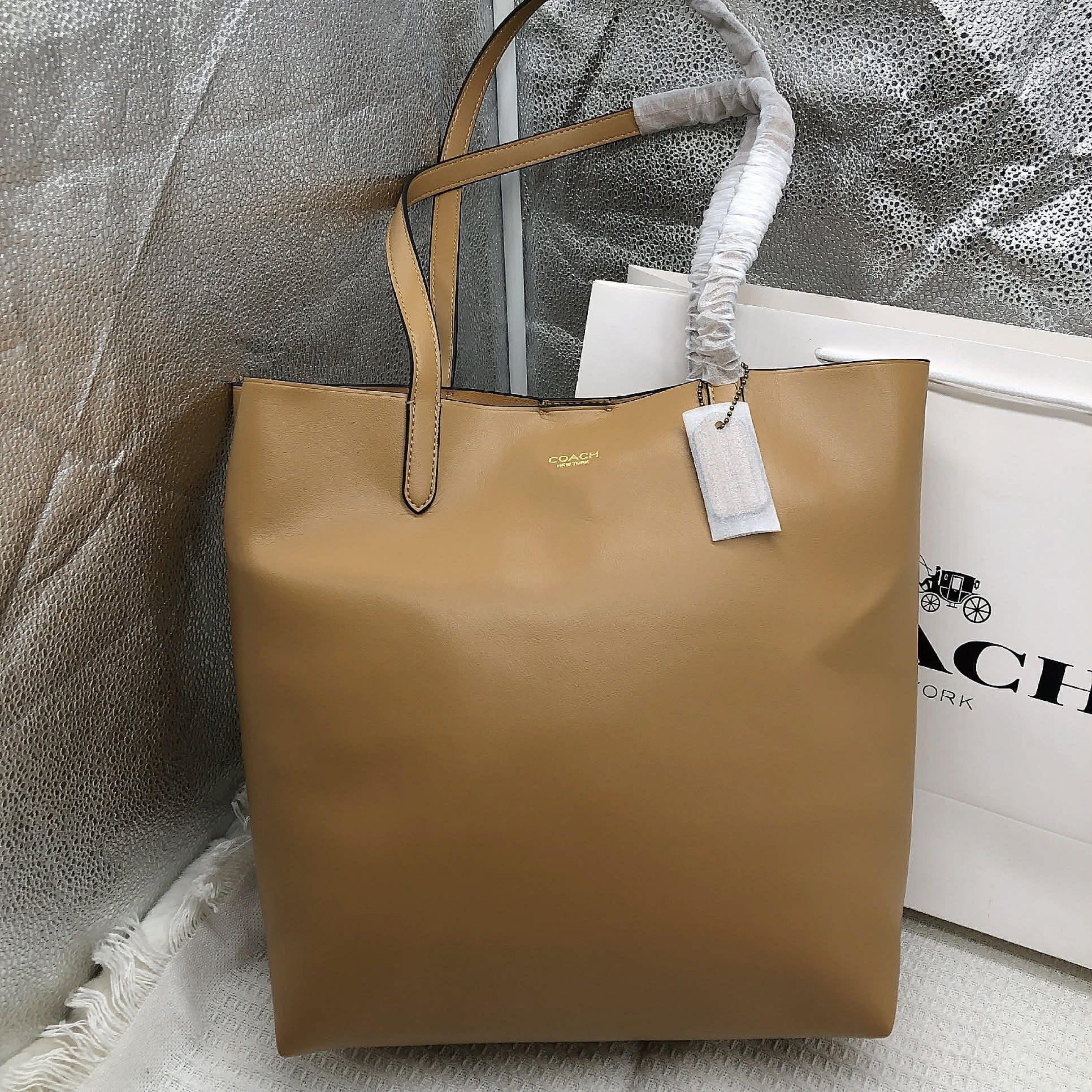 Coach Reversible City Tote Bag (Category: Luxury Bags & Wallets) located in Manila. Submitted by clairetot (Listing ID 1420093082, Image 2). Description: Coach reversible city tote bag features a spacious interior and a magnetic snap closure. It includes a detachable pouch for added organization. The bag is made of leather and has a simple, elegant design. It comes with a Coach tag attached. The bag is available in a brown and tan color..