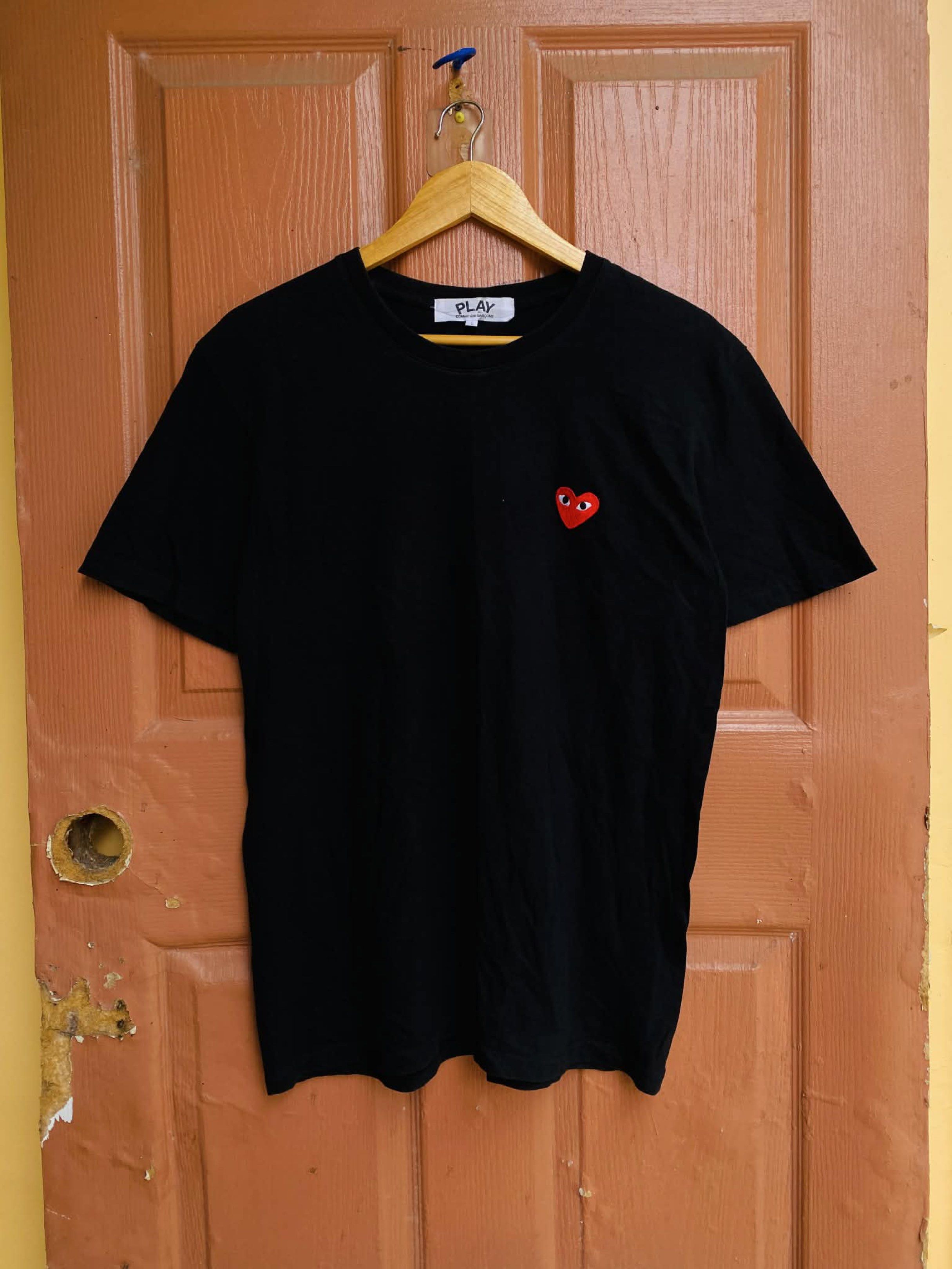 Comme des Garcons Play Black T-shirt (Category: Shirts) located in Digos. Submitted by thrifthed.ph (Listing ID 1420068499, Image 2). Description: - Comme des Garcons Play black t-shirt - Size: L -like new -dimes:21.5/28 -no issue -authentic -solid condi -solid colorate -cl:9.8/10 -need wash -complete tags -suitable for picky buyer -no return no exchange - Features the iconic red heart logo - Classic crew neck design - Short sleeves - Made from c
