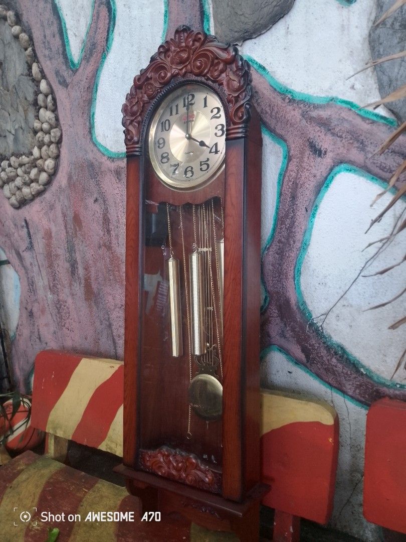 Expos Quartz Grandfather Clock (Category: Clocks) located in Caloocan City. Submitted by kaymatias (Listing ID 1420034968, Image 2). Description: - Expos Quartz Grandfather Clock - Elegant dark brown wooden frame - Gold-colored clock face - Features pendulum and three weights - Made in Korea - Decorative carvings at the top approx size 15"x5.5x57" north caloocan area,pick up only.