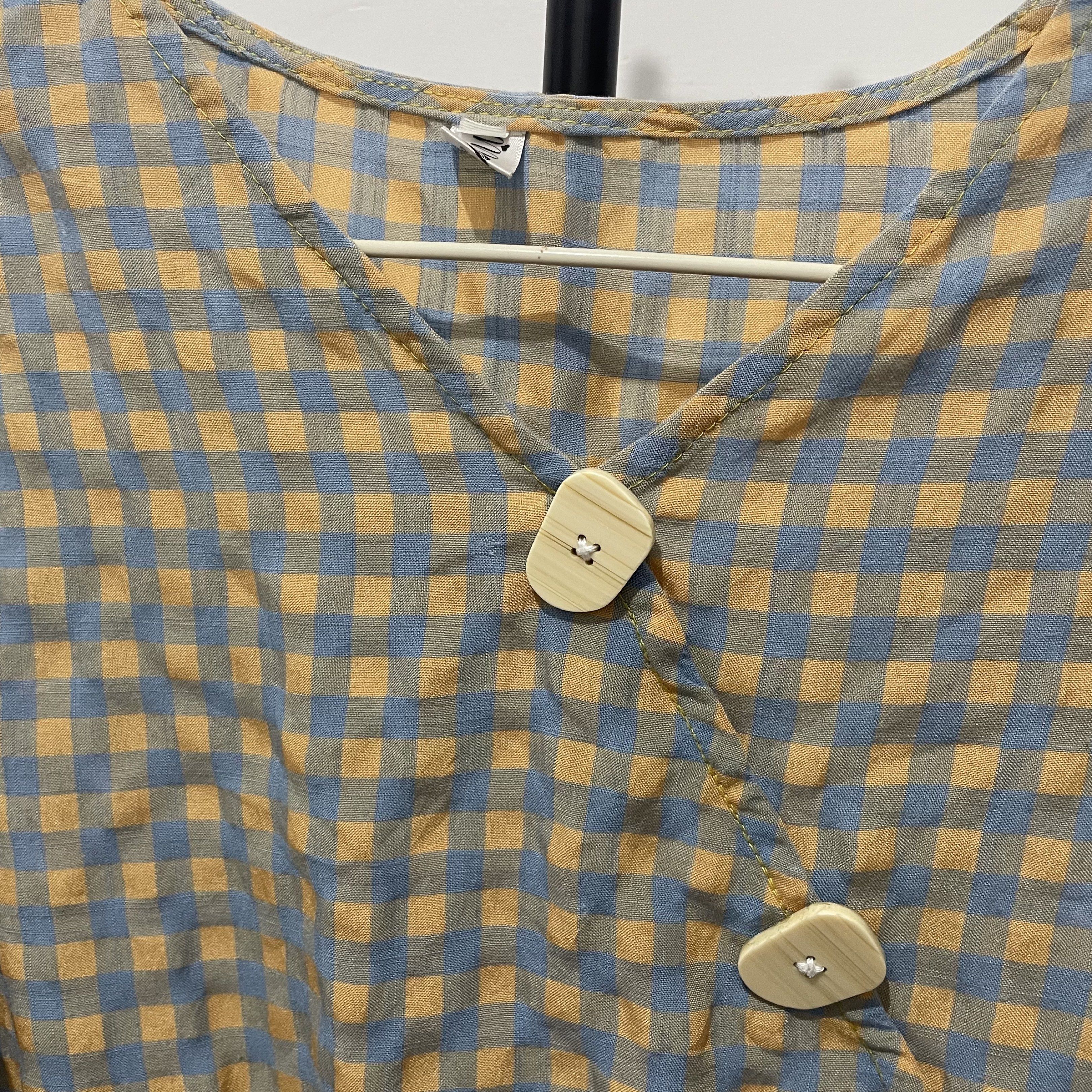 Gingham Check Blouse with Wooden Buttons (Category: Blouses) located in Manila. Submitted by reloom (Listing ID 1420120594, Image 2). Description: - can be for small to medium -Gingham check pattern in blue and yellow - Long sleeves with ruffled cuffs - Cinched waist - V-neckline - Fastened with two wooden buttons - Lightweight fabric.
