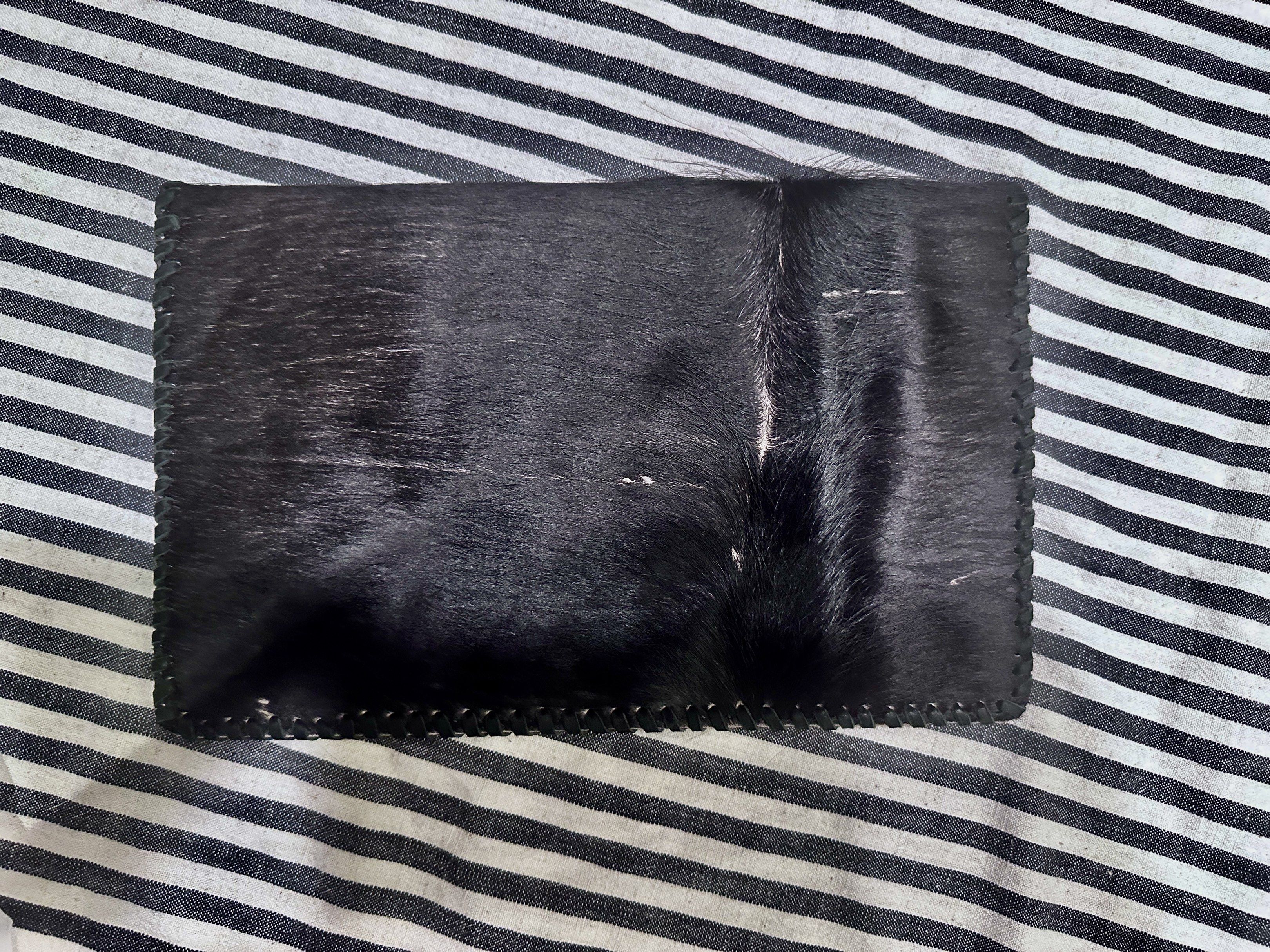 Leather Cowhide Clutch (Category: Clutches) located in Quezon City. Submitted by theessentialedit (Listing ID 1420052836, Image 2). Description: - Genuine cowhide leather - Unique black and white pattern on the front - Solid black leather back - Stitched border - Interior zipper pocket - Perfect for carrying essentials.