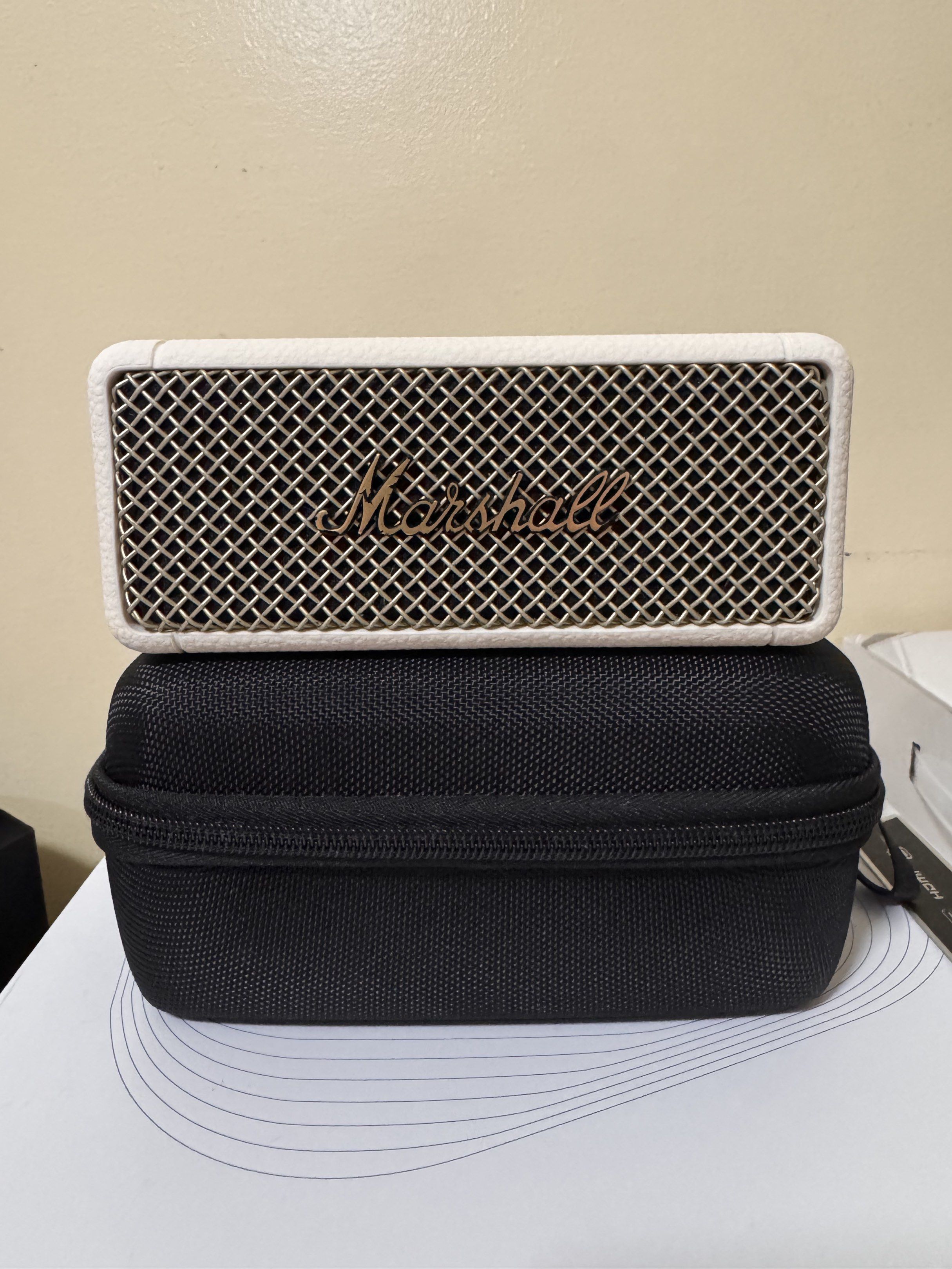 Marshall Emberton II Portable Bluetooth Speaker (Category: Soundbars, Speakers & Amplifiers) located in Manila. Submitted by ydnar.ph (Listing ID 1420085162, Image 1). Description: Marshall Emberton II is a compact portable Bluetooth speaker. It features a white exterior with the Marshall logo on the front. The speaker is shown with a black carrying case. The back of the speaker has a power input. The bottom of the speaker has the model informati