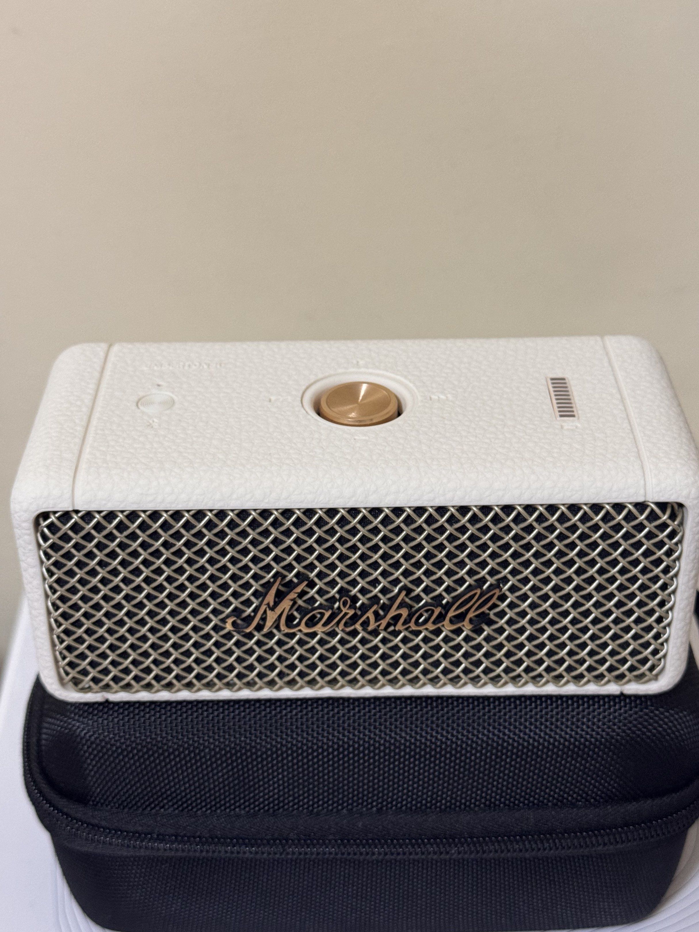 Marshall Emberton II Portable Bluetooth Speaker (Category: Soundbars, Speakers & Amplifiers) located in Manila. Submitted by ydnar.ph (Listing ID 1420085162, Image 2). Description: Marshall Emberton II is a compact portable Bluetooth speaker. It features a white exterior with the Marshall logo on the front. The speaker is shown with a black carrying case. The back of the speaker has a power input. The bottom of the speaker has the model informati
