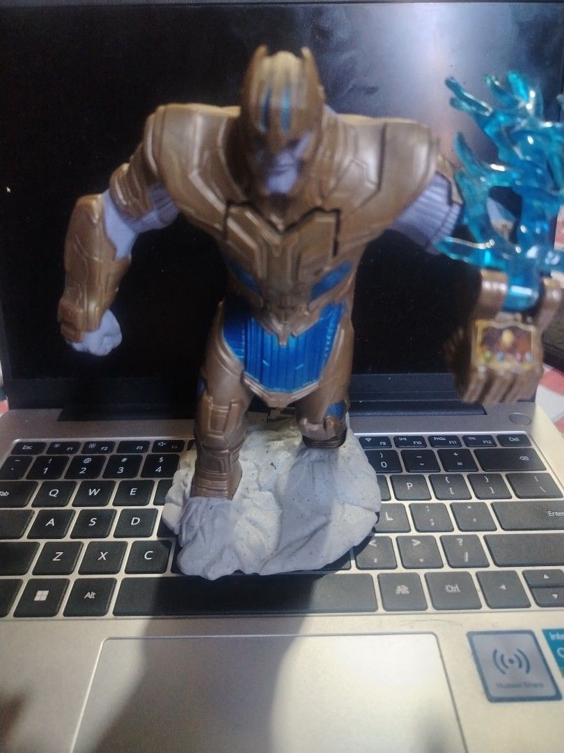 Marvel Thanos Action Figure (Category: Figurines & Statues) located in Manila. Submitted by lee.enriquez (Listing ID 1420030275, Image 1). Description: - Thanos action figure - Detailed design with gold and blue armor - Includes a base - Features a blue energy effect - Standing pose - Collectible item for Marvel fans.