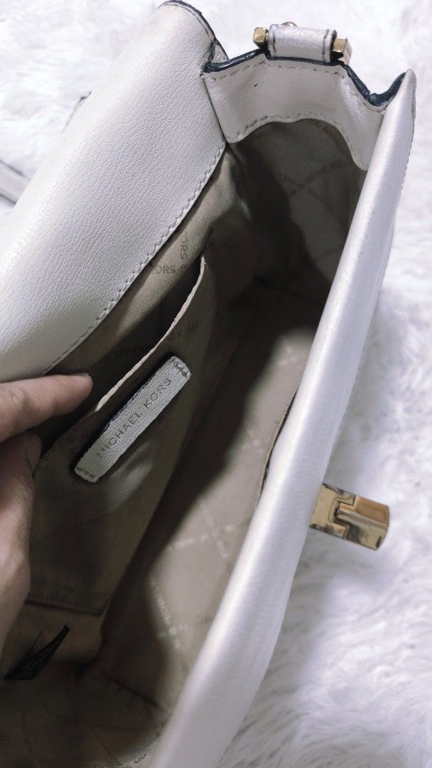 Michael Kors White Shoulder Bag (Category: Luxury Bags & Wallets) located in Cavite. Submitted by csl_corner (Listing ID 1420047058, Image 3). Description: - Michael Kors shoulder bag - Gold-tone chain strap - Gold-tone clasp closure - Interior with multiple compartments - Michael Kors branded lining - Rectangular shape 24 x 7.5 x 17cm 💯 Authentic Original *dirty needs cleaning *dents on edging selling low selling low✨.