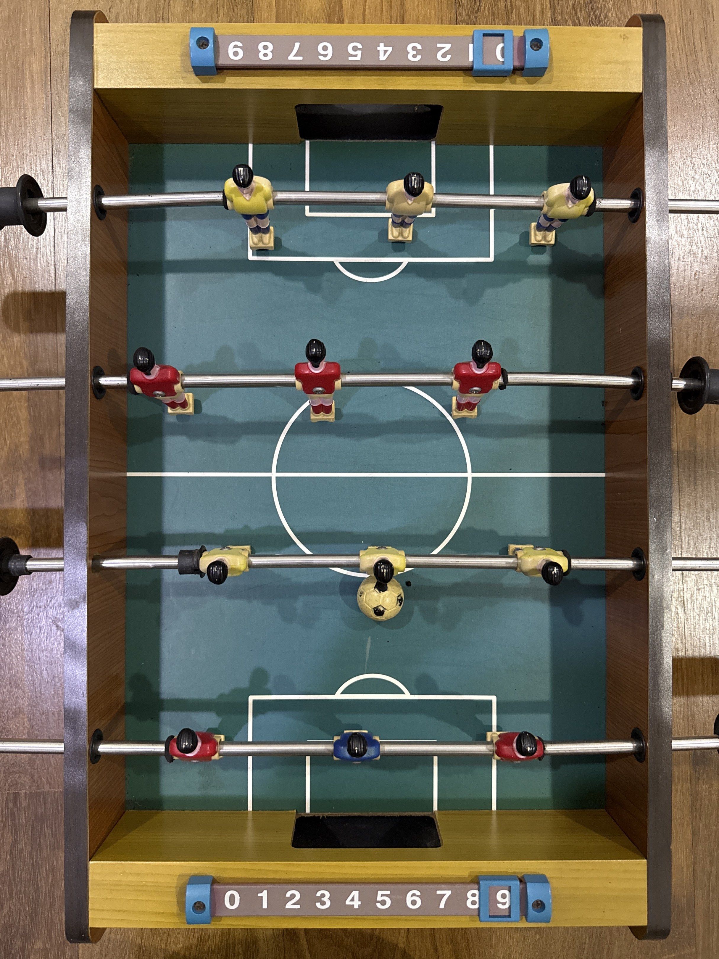 Mini Foosball Table (Category: Kids Toys) located in Kuala Lumpur. Submitted by xuan99900 (Listing ID 1420130413, Image 2). Description: - Compact foosball table -47cm x 31cm - Green playing surface with white markings - Includes yellow, red, and blue player figures - Score counters on both ends - Fun for kids and adults!.