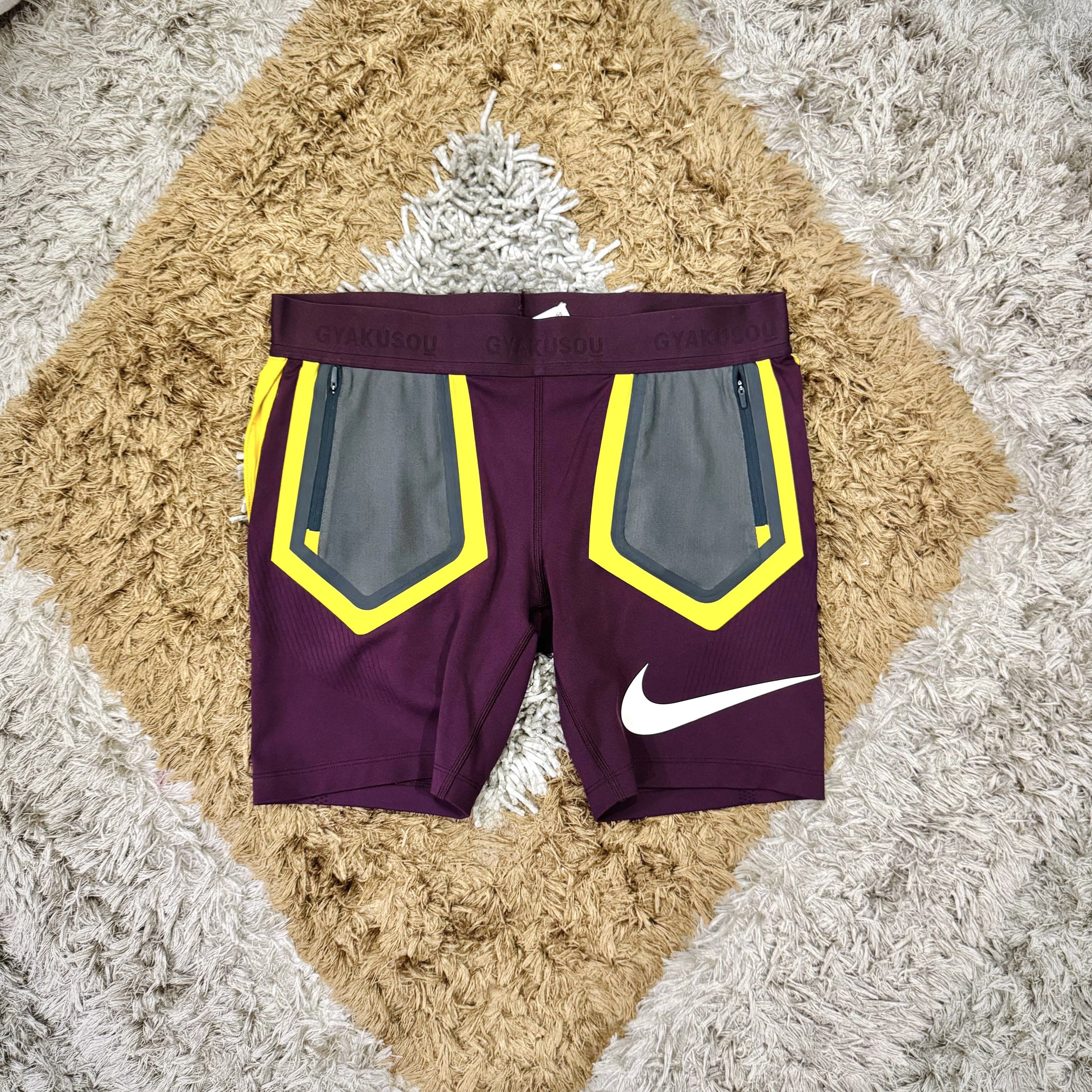 Nike Gyakusou Running Shorts (Category: Activewear) located in Manila. Submitted by visvim24 (Listing ID 1419985434, Image 2). Description: - Nike Gyakusou running shorts - Deep purple color with yellow and gray accents - Multiple pockets: zippered side pockets and back pocket - "68" print on one leg - Nike swoosh logo - "GYAKUSOU" waistband branding.