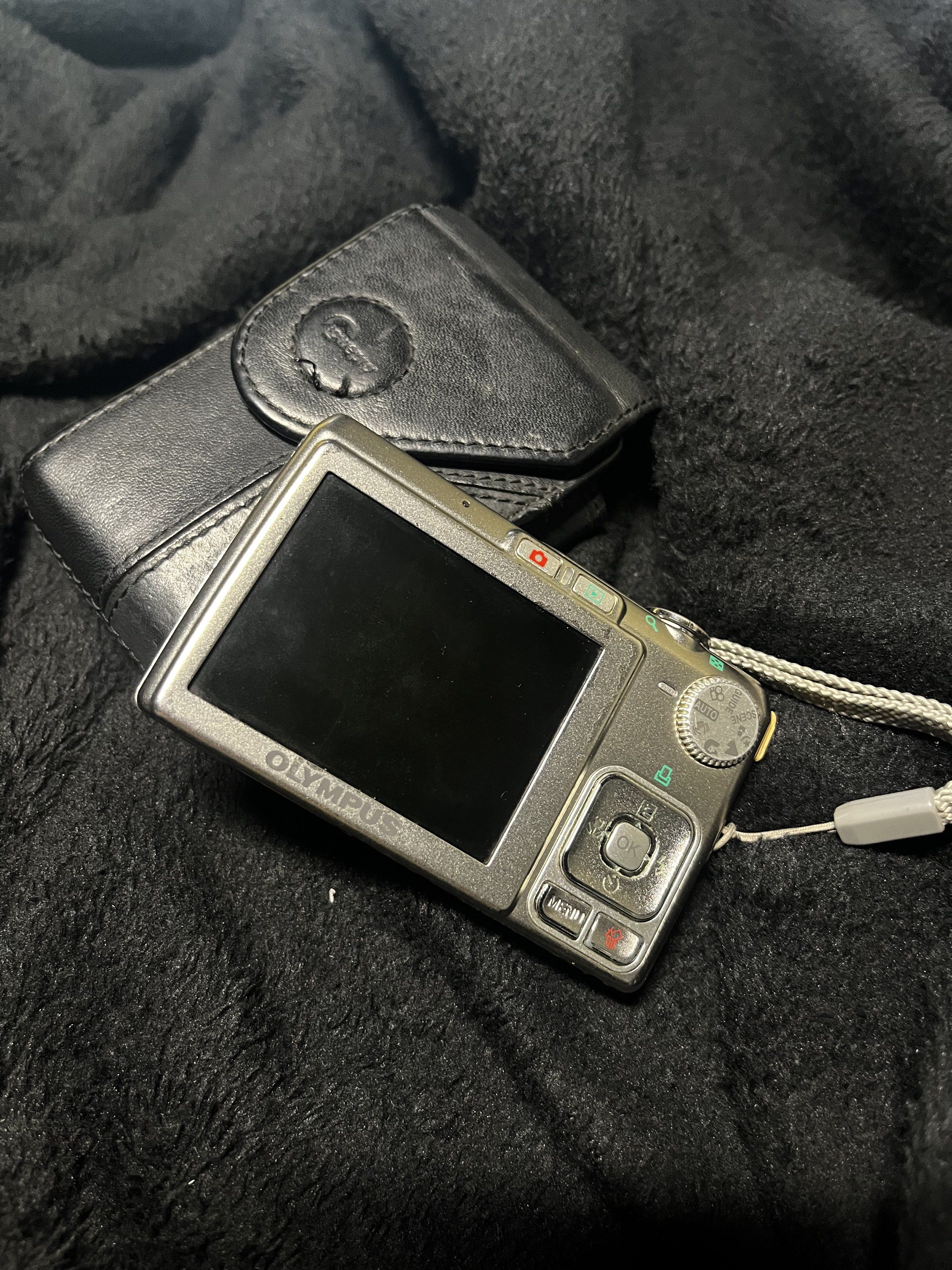 Olympus FE-230 Digital Camera (Category: Cameras) located in Caloocan City. Submitted by plrsm (Listing ID 1419990083, Image 2). Description: Olympus FE-230 digital camera with a protective case and strap. The camera has a silver body and a built-in flash. It features a lens with a 6.3-18.9mm focal length. The camera's screen displays a captured image. Includes a case with a strap for easy carrying. issues: • lcd burn • pink/green lines on screen