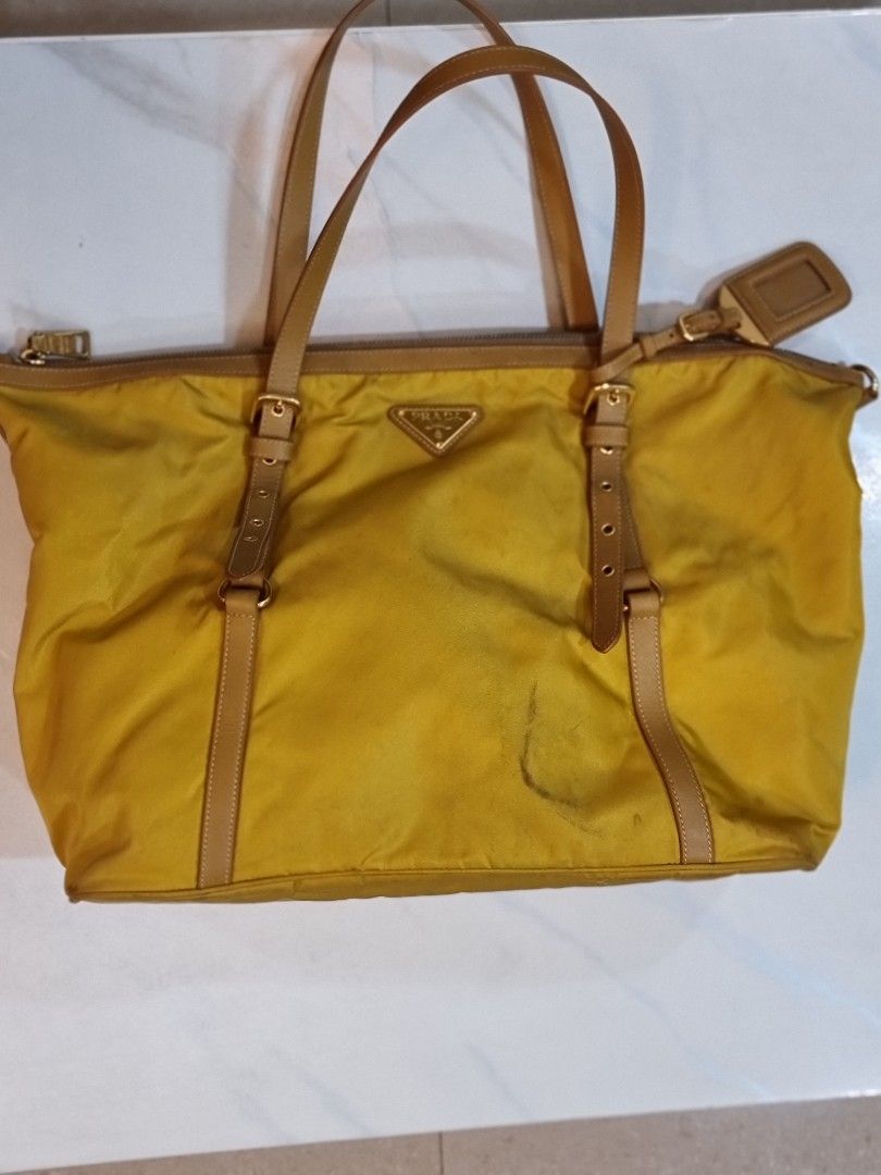 Prada Tessuto Saffiano nylon tote bag (Category: Luxury Bags & Wallets) located in Pasig City. Submitted by sfork (Listing ID 1420124641, Image 3). Description: - Authentic Prada tote bag - Yellow nylon with leather accents - Zip closure - Gold-toned hardware - Detachable luggage tag - Double handles and adjustable straps - Matching yellow interior lining - Visible signs of wear.