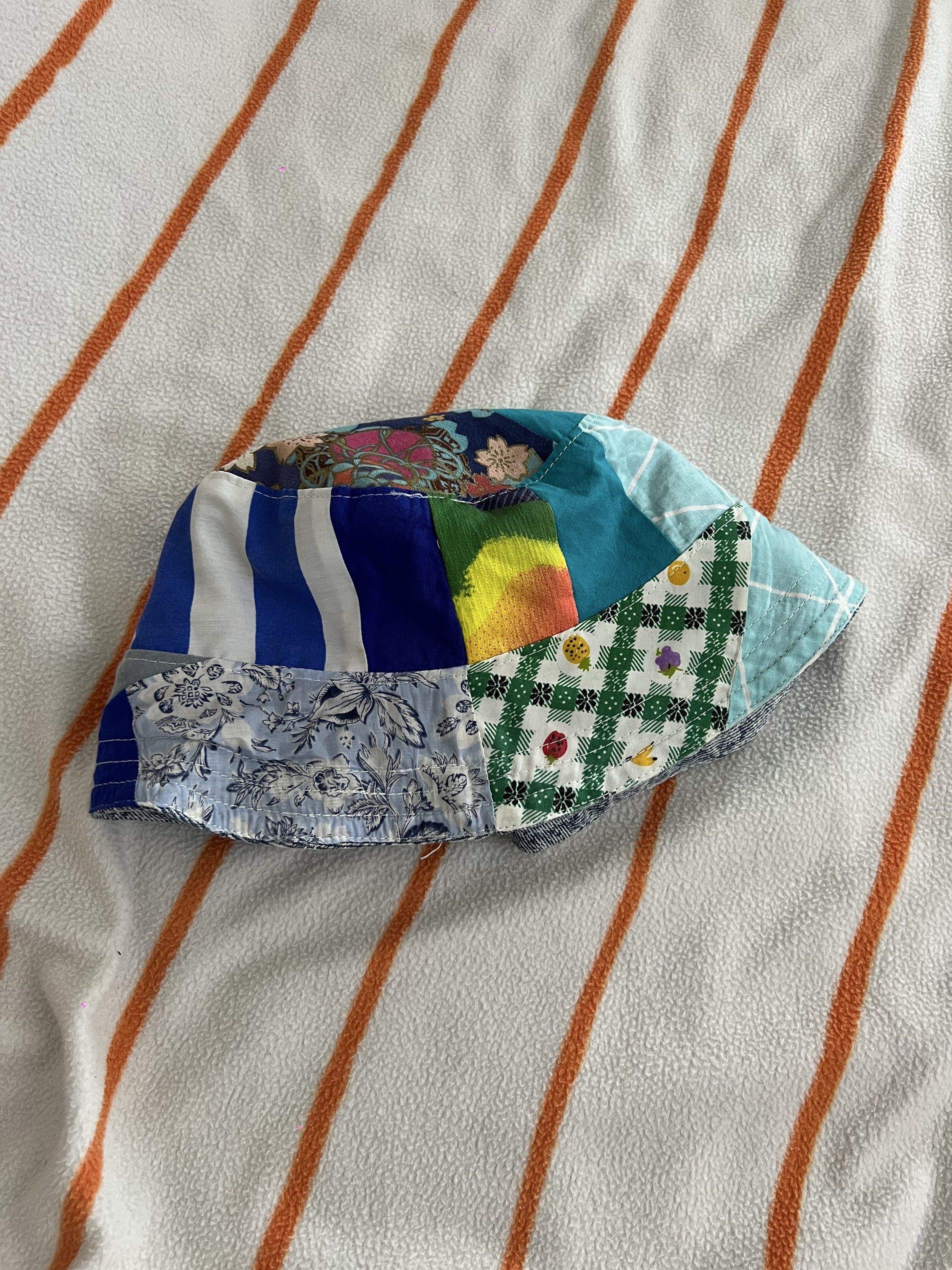 Reversible Patchwork Bucket Hat (Category: Babies & Kids Fashion) located in Singapore. Submitted by l0773 (Listing ID 1420006535, Image 2). Description: - Reversible design - One side: Denim wash - Other side: Colorful patchwork - Adds personality to your outfit - Provides sun protection - Stylish and versatile.