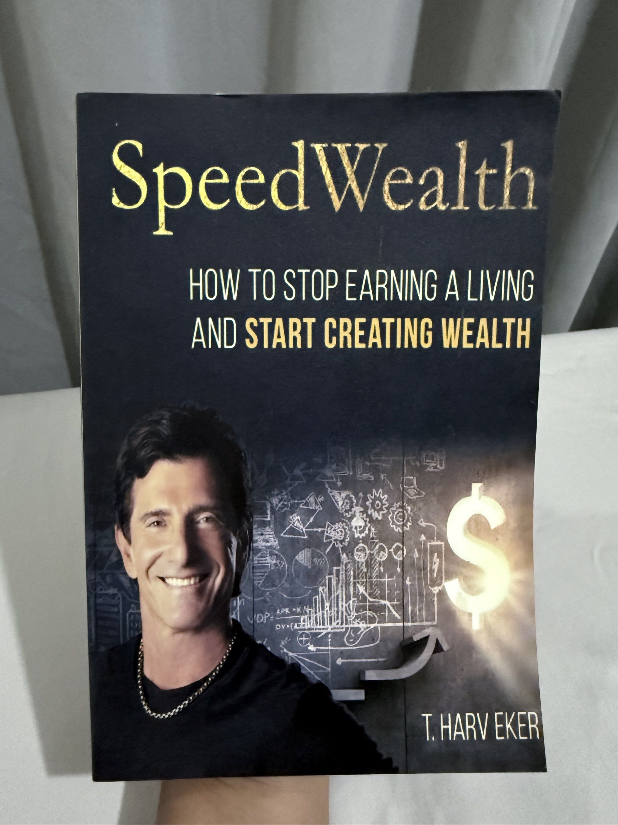 SpeedWealth by T. Harv Eker (Category: Storybooks) located in Mansalay. Submitted by declutterandco (Listing ID 1420114639, Image 1). Description: - SpeedWealth by T. Harv Eker - Learn wealth-building strategies - Stop earning a living, start creating wealth - Features the author on the cover - Gold lettering on the cover.