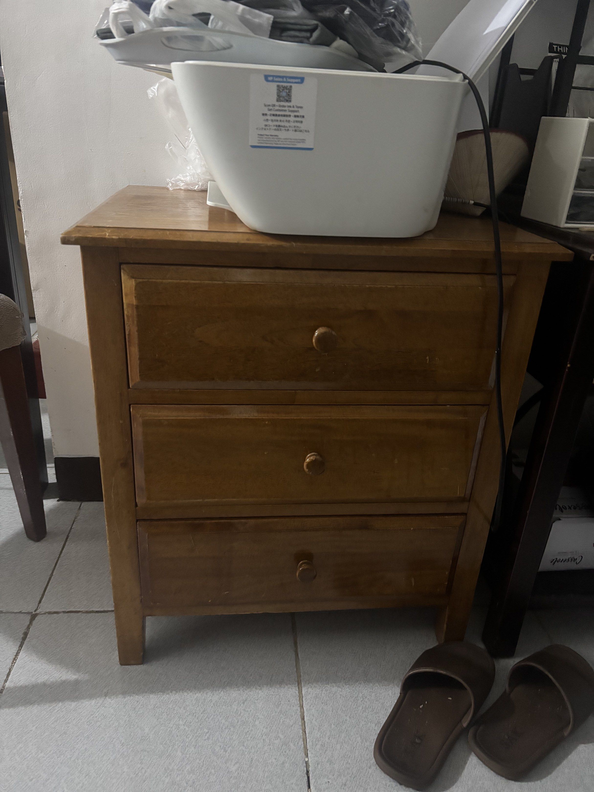Wooden Nightstand with 3 Drawers (Category: Shelves, Cabinets & Racks) located in Paranaque City. Submitted by coconati (Listing ID 1419997630, Image 1). Description: - Wooden nightstand - Three drawers - Warm wood tone - Simple design - Round wooden knobs - Four legs - Ideal for bedroom or living room - height 60cm - width 52cm.