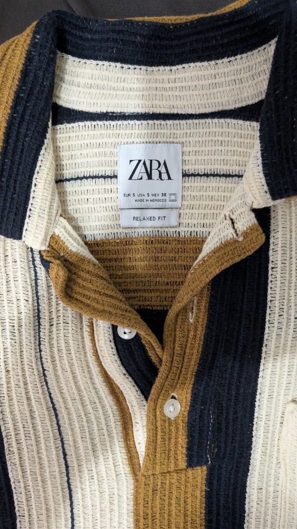 Zara Striped Polo Shirt (Category: Tshirts & Polo Shirts ) located in Makati City. Submitted by _mandalafinds (Listing ID 1420028559, Image 2). Description: - Zara polo shirt - Striped design - Collared neckline - Short sleeves - Chest pocket - Button-up placket - Textured knit fabric - Color scheme: White, navy, and brown stripes.