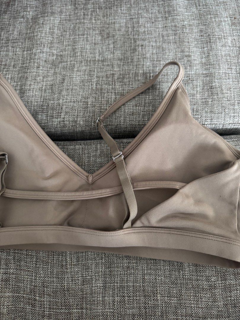 Activewear Sports Bra (Category: Activewear) located in Quezon City. Submitted by cessdecluttering (Listing ID 1420230822, Image 3). Description: - V-neck sports bra - Adjustable straps for a custom fit - Subtle logo detail - Made of smooth, possibly moisture-wicking material - Hook-and-eye closure at the back - Neutral light brown color.