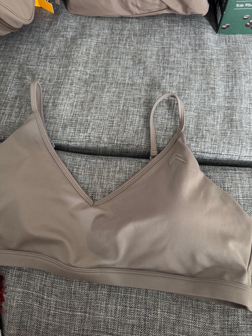 Activewear Sports Bra (Category: Activewear) located in Quezon City. Submitted by cessdecluttering (Listing ID 1420230822, Image 1). Description: - V-neck sports bra - Adjustable straps for a custom fit - Subtle logo detail - Made of smooth, possibly moisture-wicking material - Hook-and-eye closure at the back - Neutral light brown color.