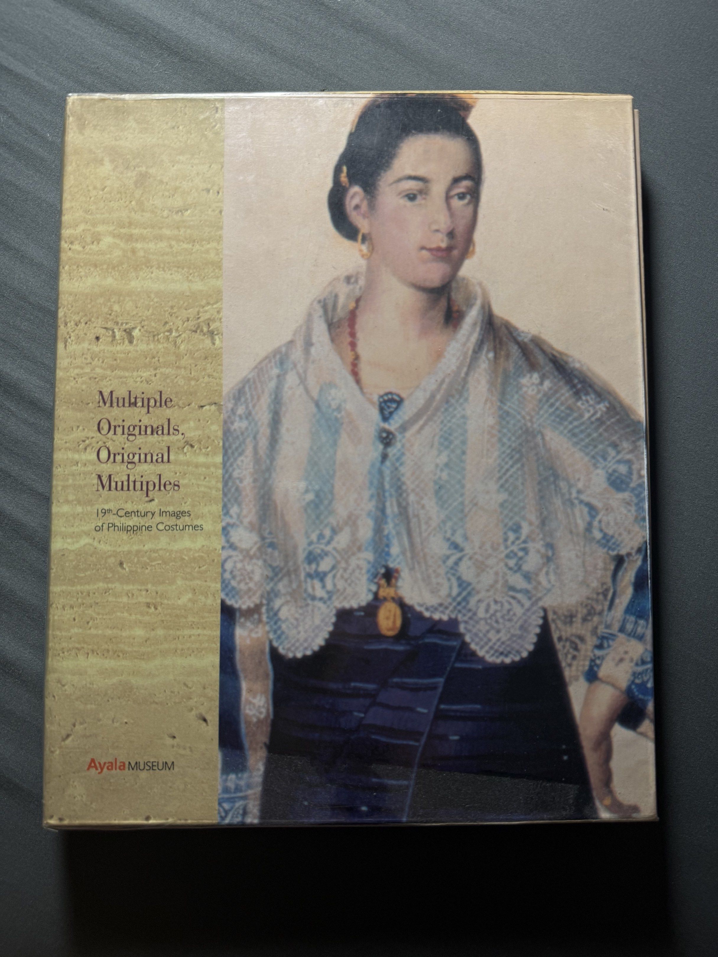 Ayala Museum Book: Multiple Originals, Original Multiples (Category: Storybooks) located in Balamban. Submitted by jvc1920 (Listing ID 1420186135, Image 1). Description: - Ayala Museum book - Features 19th-century images of Philippine costumes - Ideal for those interested in Philippine history and culture.