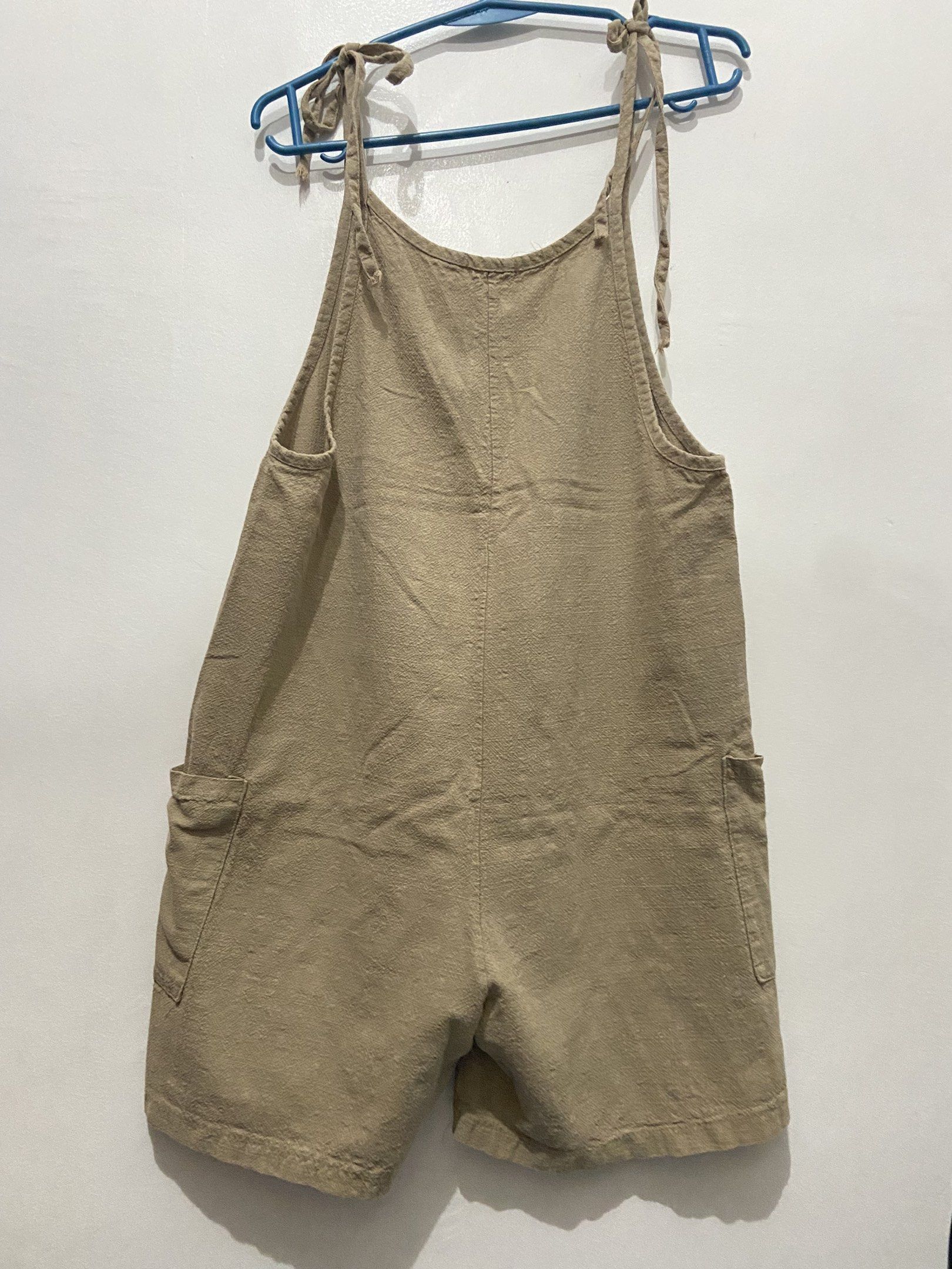 Beige Romper Overalls (Category: Jumpsuits) located in Pasay City. Submitted by trixietrix (Listing ID 1420259666, Image 2). Description: - Beige romper overalls - Adjustable tie straps - Two front pockets - Relaxed fit - Textured fabric - Oversized for petite/small frame, loose-fit on medium frame.