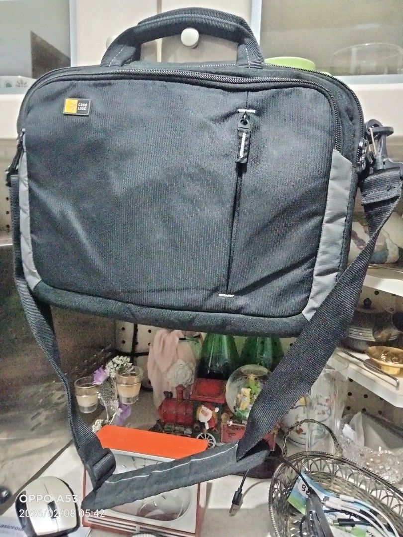 Case Logic Laptop Bag (Category: Laptop Bags & Sleeves) located in Carmona. Submitted by rpute (Listing ID 1420347243, Image 2). Description: - Black Case Logic laptop bag - Includes a shoulder strap and handle - Features a zippered front pocket - Teal interior lining - Multiple interior compartments - Case Logic logo on the front.