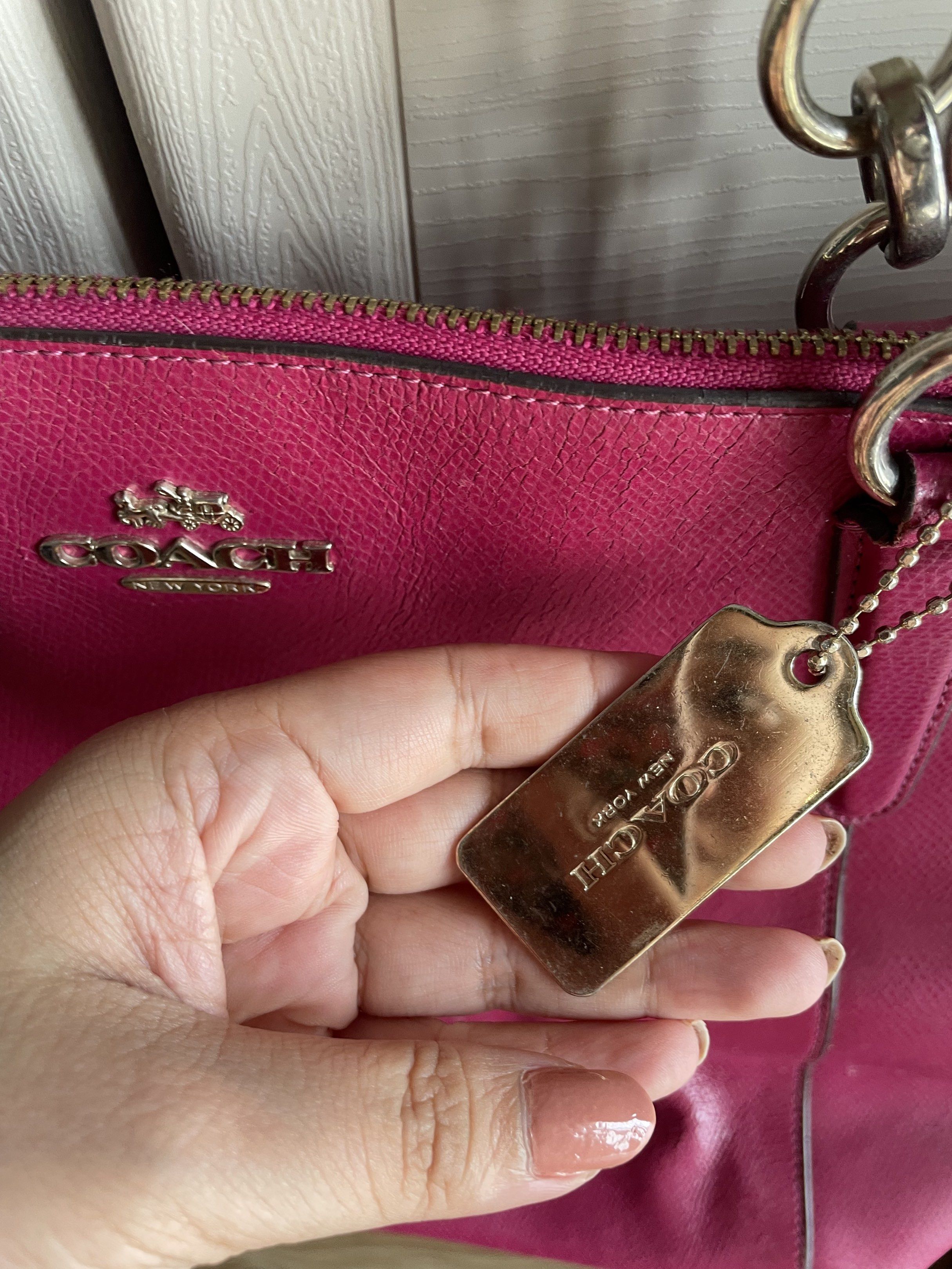 Coach Ava Leather Tote Bag (Category: Luxury Bags & Wallets) located in Caloocan City. Submitted by claudia10019667 (Listing ID 1420195144, Image 2). Description: - Authentic Coach tote bag - Vibrant pink/magenta color - Size: 16 3/4 (L) x 9 3/4 (H) x 5 (W) (kasya 13 inch laptop) - Zip closure - Silver-tone hardware - Includes Coach hang tag - Double handles - Spacious interior - Features Coach label inside - Minor wear on handles and body.