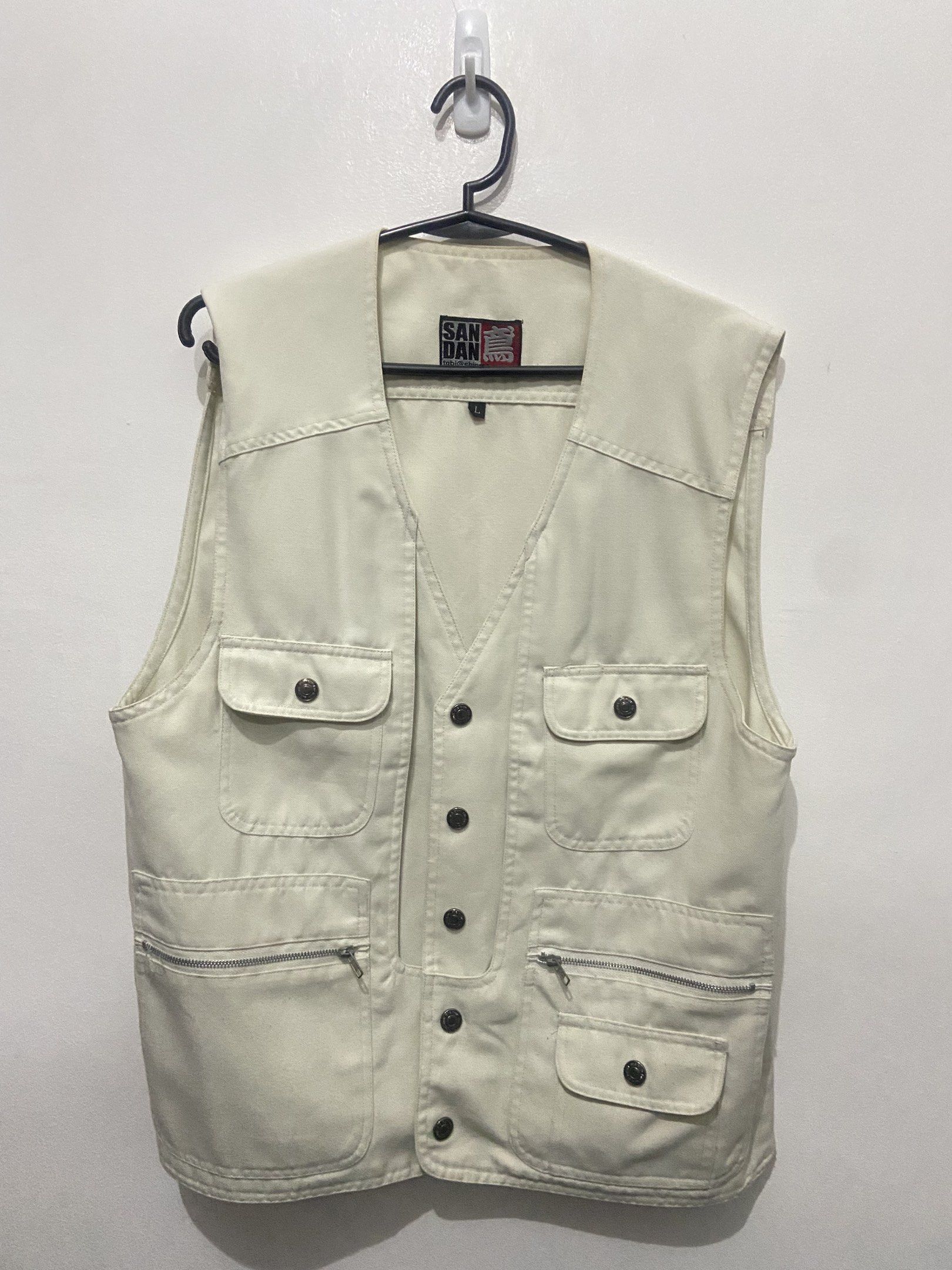Dirty White/Cream Denim Vest (Category: Others Tops) located in Pasay City. Submitted by trixietrix (Listing ID 1420274742, Image 1). Description: - Cream-colored vest - Button-down front - V-neck design - Two chest pockets with button closures - Two lower pockets with zipper and button closures - Classic, utilitarian style.