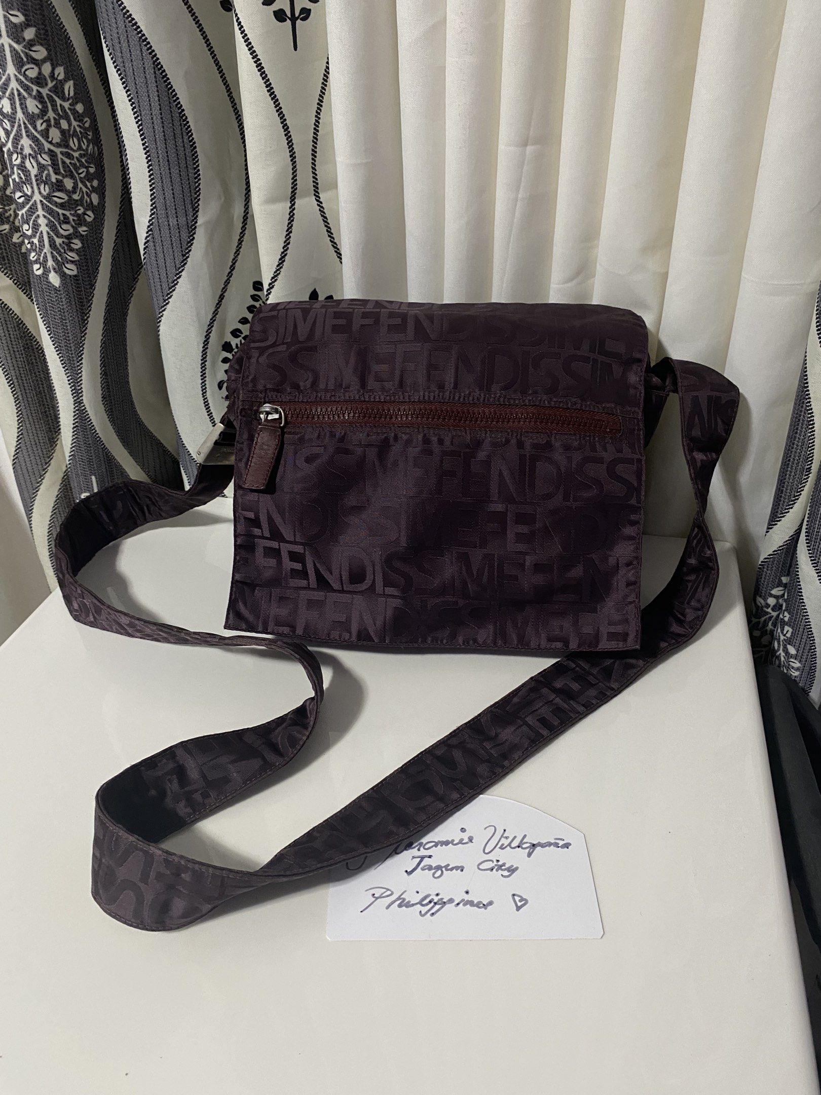 FENDISSIME Crossbody Bag (Category: Luxury Bags & Wallets) located in Tagum. Submitted by amarasluxbag (Listing ID 1420298535, Image 1). Description: - FENDISSIME crossbody bag - Repeating logo pattern - Zippered main compartment - Secondary zippered pocket inside - Adjustable shoulder strap - Textured interior lining - Metal buckle with brand name - Made in Italy With sign of use Mayparang tinahi na part Maganda color neto Magaan lang .