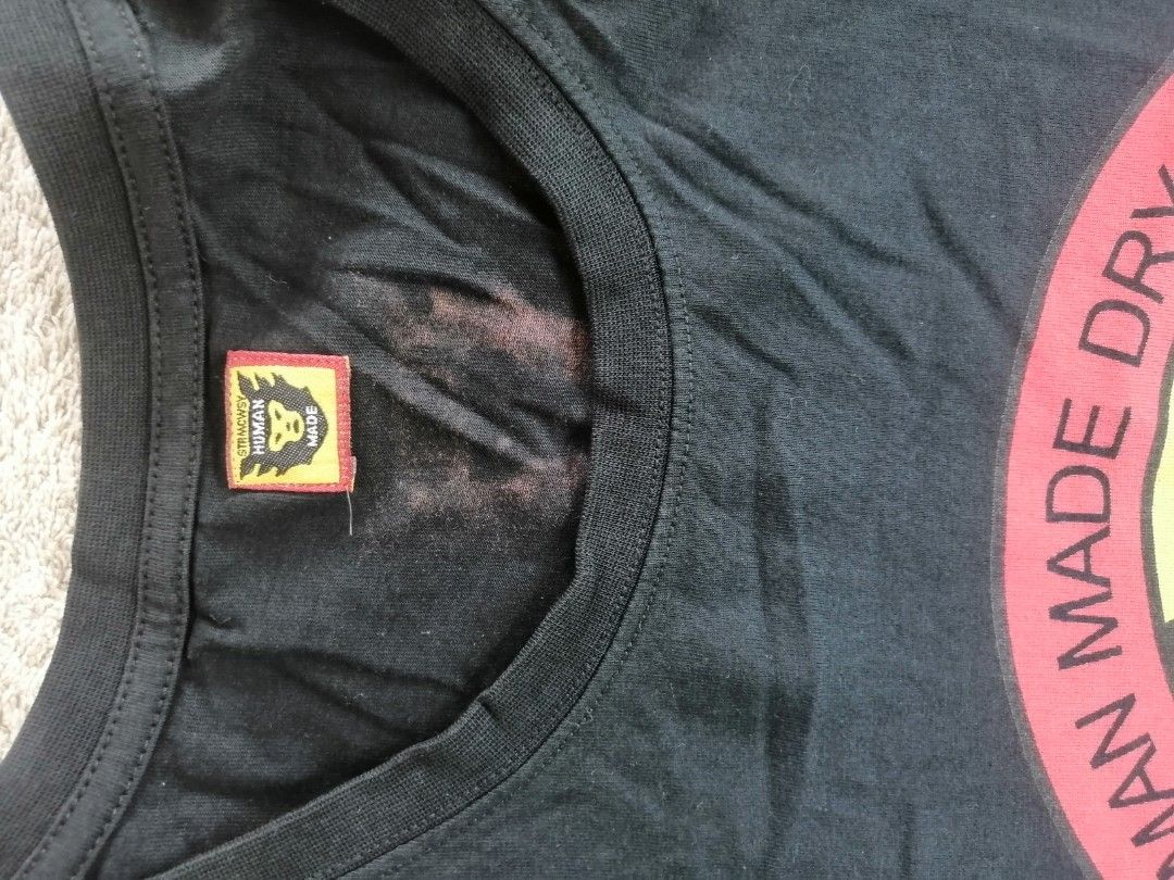Human Made Dry Alls T-shirt (Category: Tshirts & Polo Shirts ) located in Andop. Submitted by source8600 (Listing ID 1420209590, Image 3). Description: - Human Made Dry Alls T-shirt - Black color - Features circular graphic on front and back - Graphic includes "HUMAN MADE DRY ALLS" and "GEARS FOR FUTURISTIC TEENAOERS" text - Crew neck - Small collar tag - Minor stains present.
