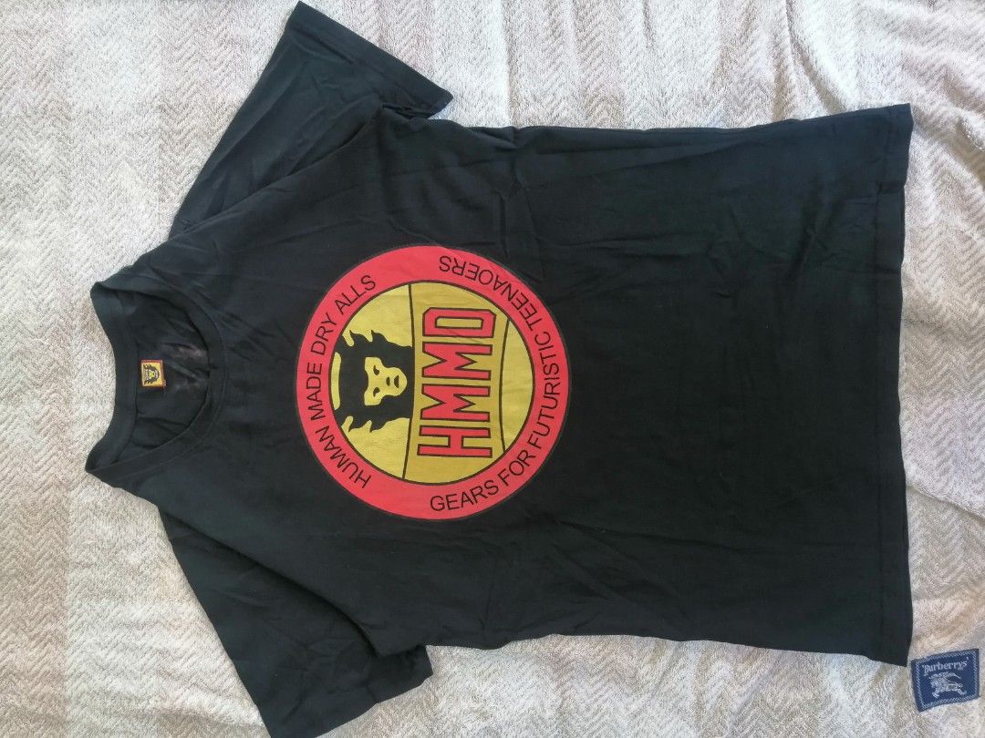 Human Made Dry Alls T-shirt (Category: Tshirts & Polo Shirts ) located in Andop. Submitted by source8600 (Listing ID 1420209590, Image 1). Description: - Human Made Dry Alls T-shirt - Black color - Features circular graphic on front and back - Graphic includes "HUMAN MADE DRY ALLS" and "GEARS FOR FUTURISTIC TEENAOERS" text - Crew neck - Small collar tag - Minor stains present.