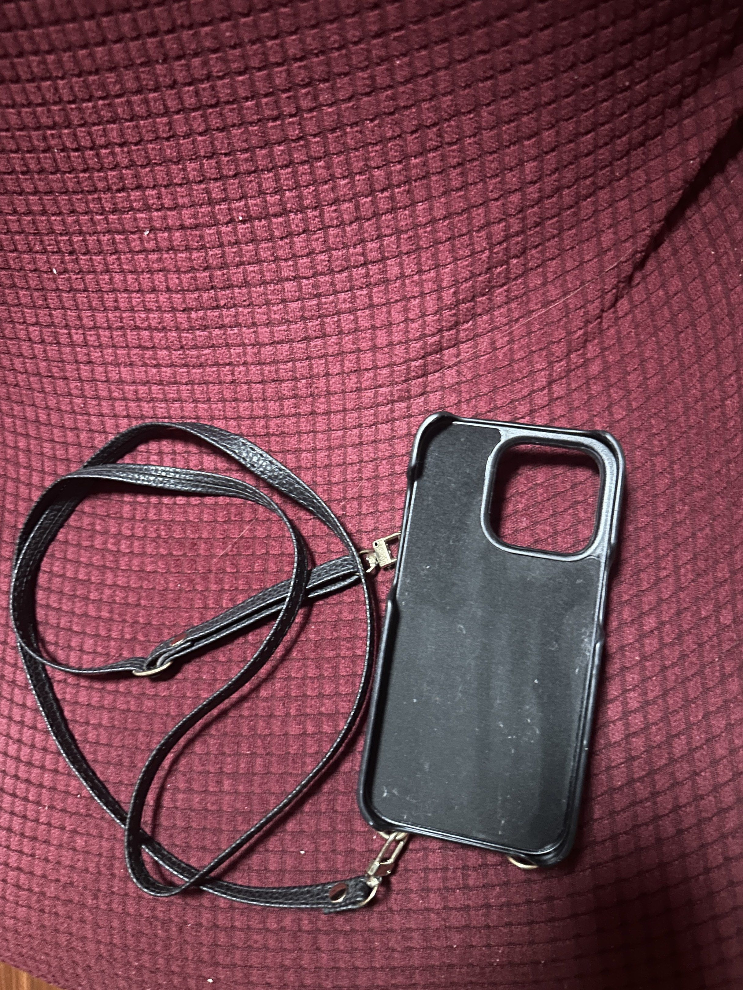 iPhone 14 Pro Black Leather Phone Case with Strap (Category: Cases & Sleeves) located in Manila. Submitted by AAA09876 (Listing ID 1420265238, Image 3). Description: Black leather phone case with a detachable strap. Features a clasp closure and a card slot. The case has a gold-colored ring for attaching the strap. The strap is adjustable and can be worn across the body or over the shoulder..