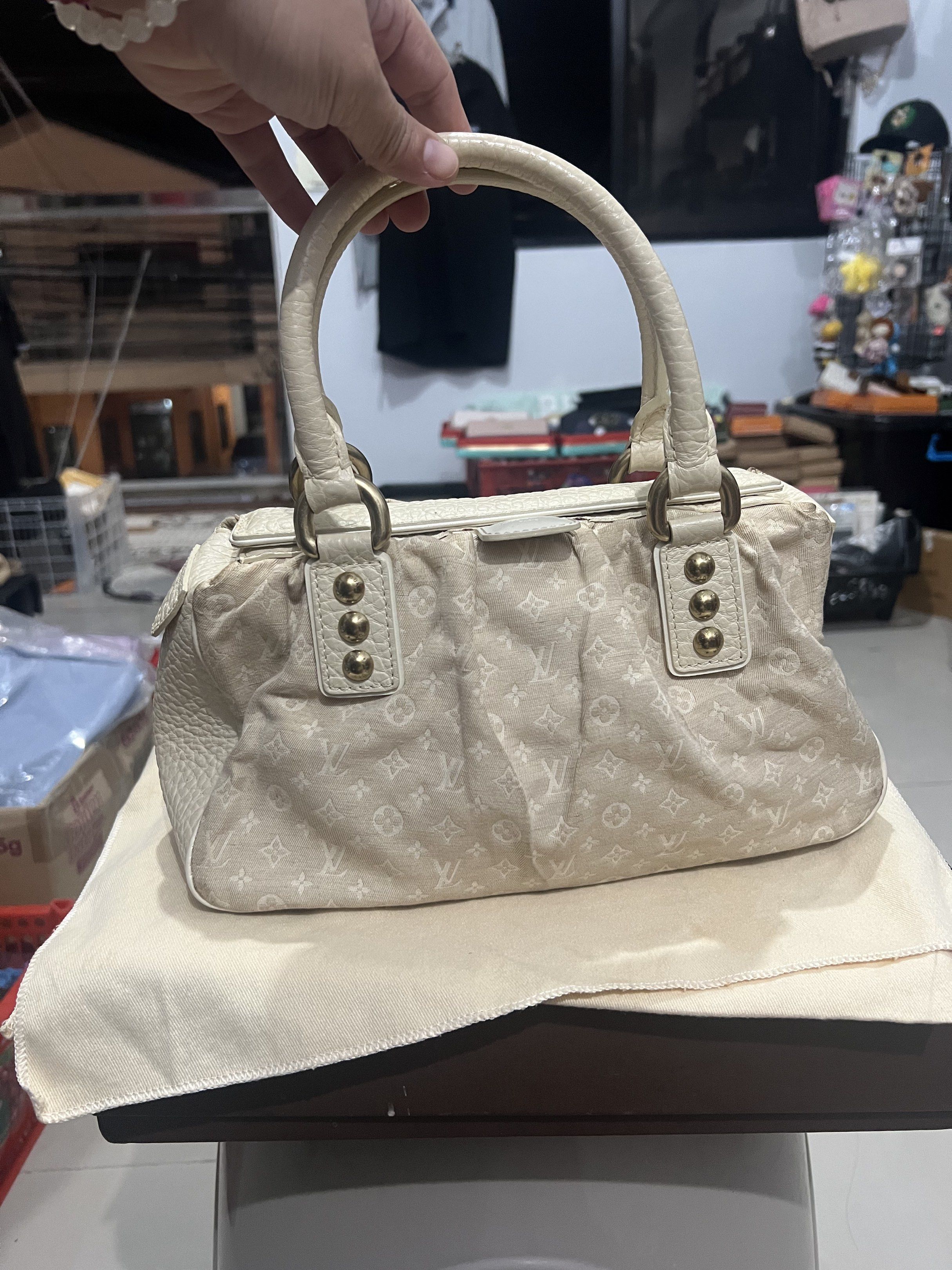 Louis Vuitton MINI LIN TRAPEZE HANDBAG (Category: Luxury Bags & Wallets) located in Bacoor. Submitted by faith.hope.love28 (Listing ID 1420271894, Image 1). Description: Elegant Louis Vuitton handbag. Features a textured white leather exterior. The interior lining has a subtle pattern. Includes gold-toned hardware accents. The bag has a structured shape with a top handle. The Louis Vuitton Paris logo is visible on a leather tag inside the bag..