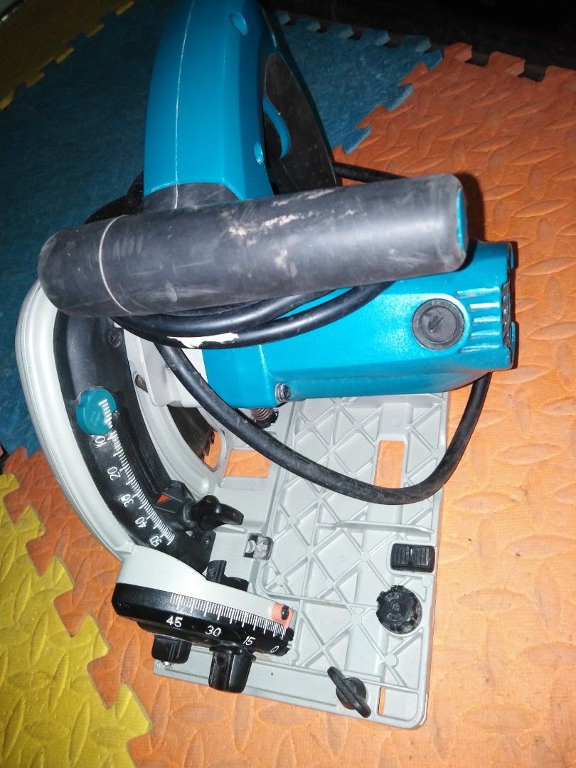 Makita SP6000 Circular Saw (Category: Construction Tools & Equipment) located in Davao. Submitted by rolandear (Listing ID 1420168617, Image 3). Description: Makita SP6000 circular saw. Features a 165mm blade, 1300W power, and operates at 220-240V. Includes a dust extraction port and adjustable cutting angles. The saw has a teal and white color scheme. The model number is visible on the side of the saw..