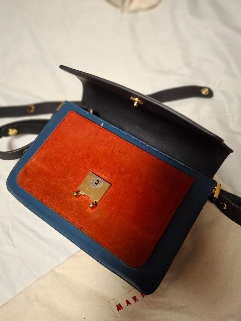 Marni Trunk Shoulder Bag (Category: Luxury Bags & Wallets) located in Ilagan. Submitted by dbankerscloset (Listing ID 1420320729, Image 2). Description: - Marni Trunk shoulder bag - Color block design - Black exterior with blue and orange accents - Detachable shoulder strap - Multiple interior compartments - Gold-tone zippers and clasp - Brand name visible on hardware - Includes dust bag.