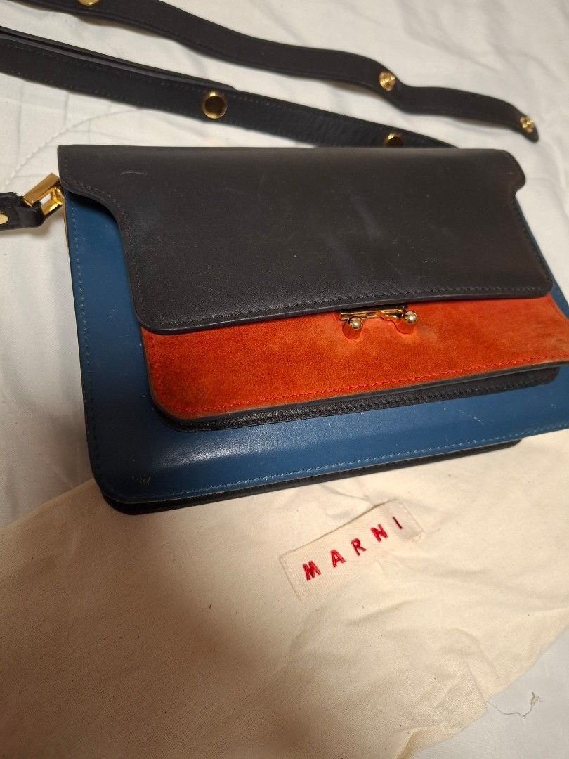 Marni Trunk Shoulder Bag (Category: Luxury Bags & Wallets) located in Ilagan. Submitted by dbankerscloset (Listing ID 1420320729, Image 1). Description: - Marni Trunk shoulder bag - Color block design - Black exterior with blue and orange accents - Detachable shoulder strap - Multiple interior compartments - Gold-tone zippers and clasp - Brand name visible on hardware - Includes dust bag.