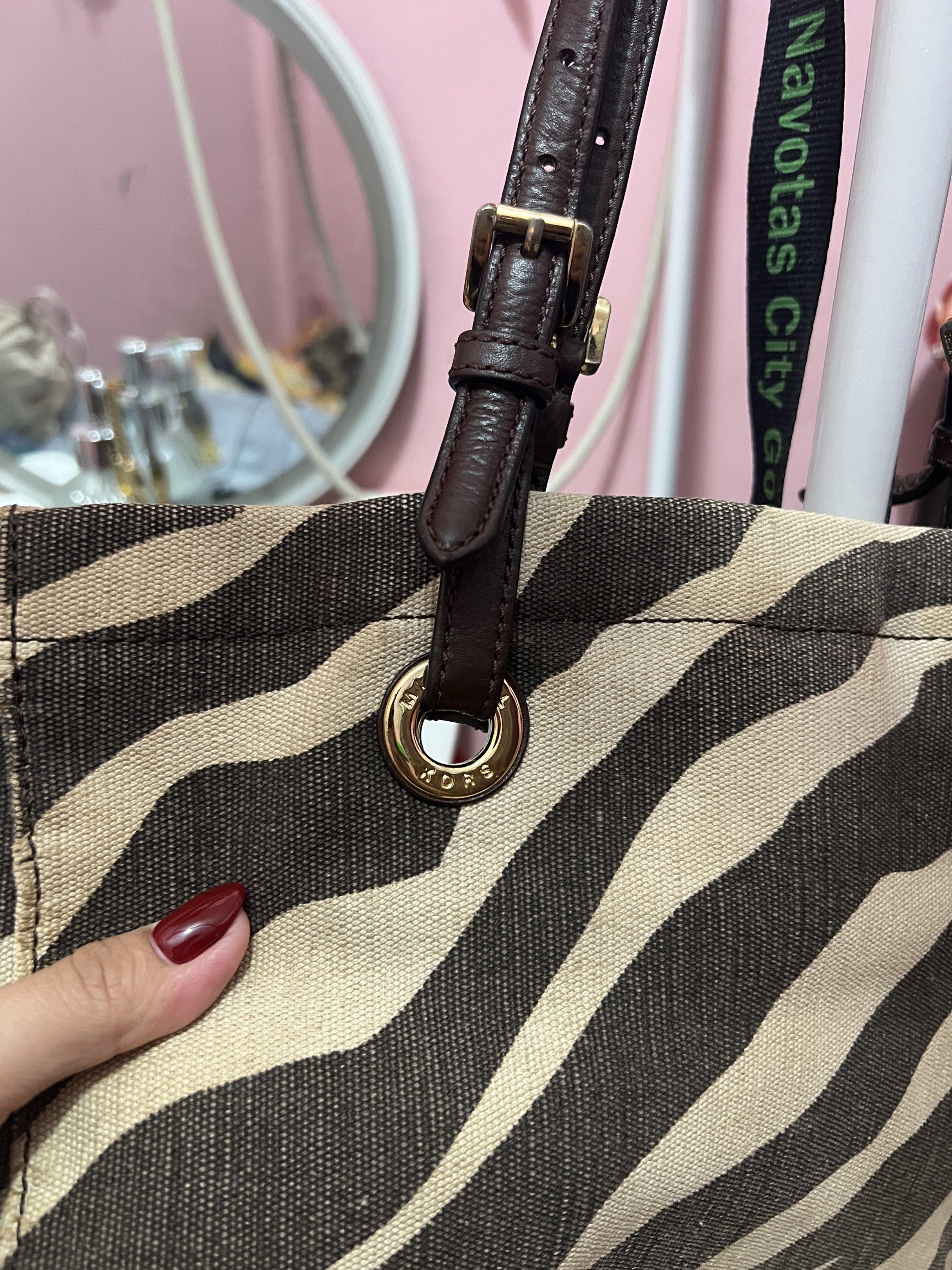 Michael Kors Zebra Print Tote Bag (Category: Tote Bags) located in Navotas City. Submitted by declutteringstuff_ph (Listing ID 1420178104, Image 2). Description: - Michael Kors tote bag - Unique zebra print design - Brown leather handles - Gold-tone hardware - Branded interior lining - Interior pockets for organization - Perfect for everyday use.