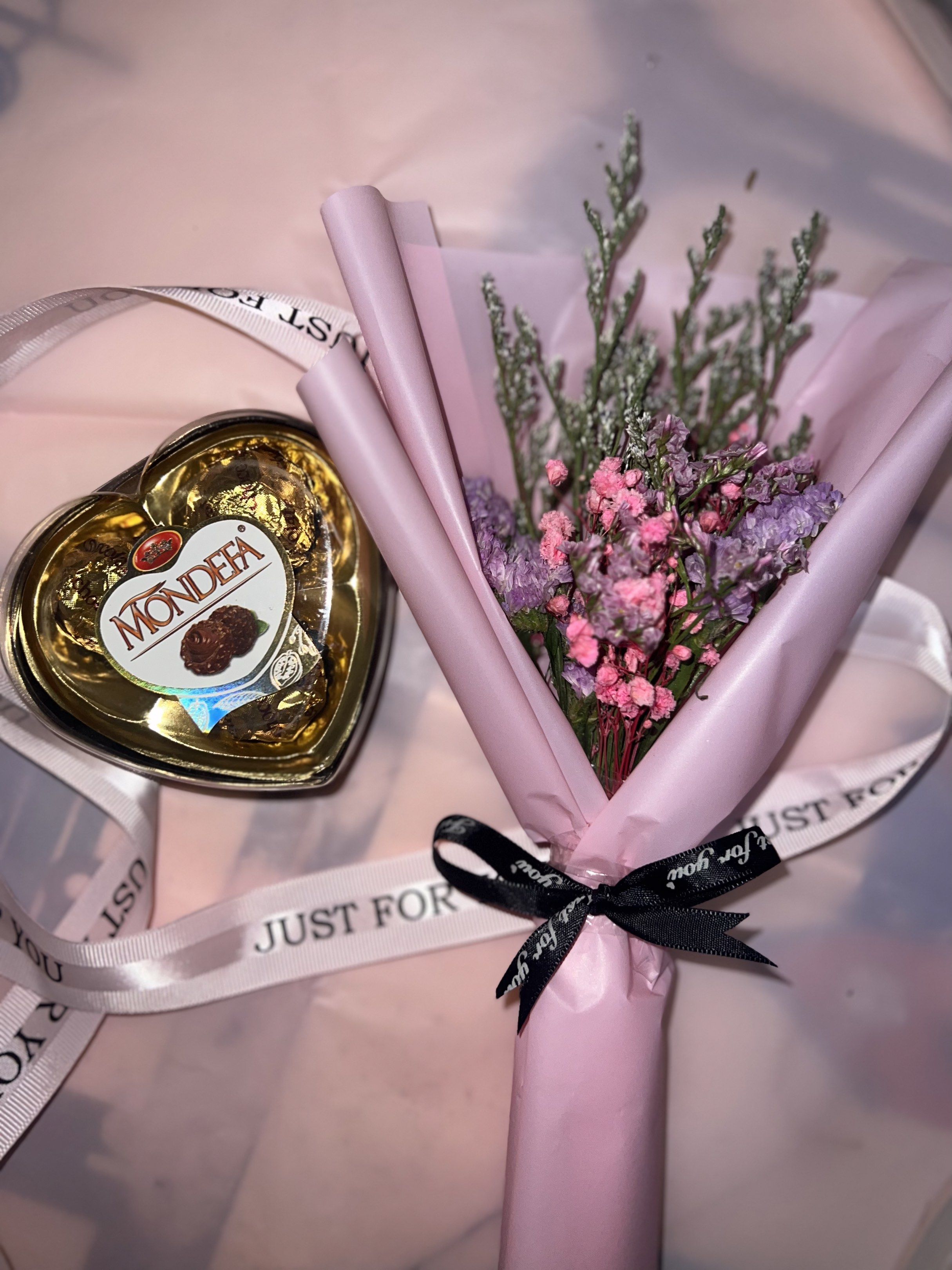 Mini bouquet with mondefa chocolate (Category: Flowers & Bouquets) located in Mandaluyong City. Submitted by samarahmay (Listing ID 1420259792, Image 1). Description: - Heart-shaped Mondefa chocolate box - Includes a small bouquet of dried flowers - Bouquet wrapped in pink paper - Tied with a black ribbon that says "Just for you" - Perfect for gifting or decoration - Ready to give -lasting up to 2 years.