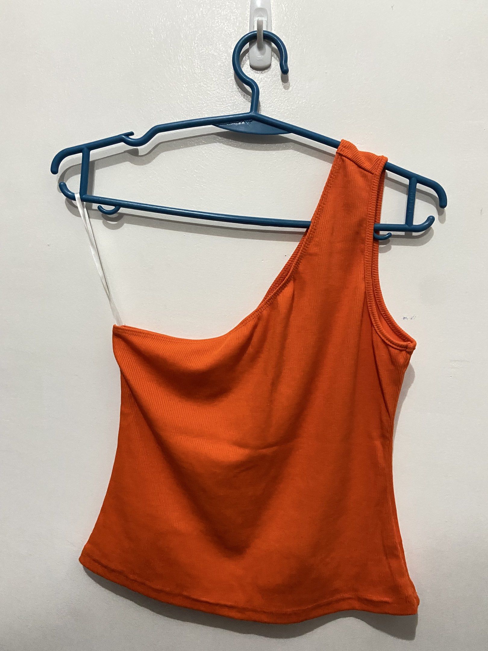 Orange One-Shoulder Top (Category: Sleeveless) located in Pasay City. Submitted by trixietrix (Listing ID 1420260960, Image 2). Description: - Bright orange one-shoulder top - Ribbed texture - Sleeveless design - Fitted silhouette - Stretchable fabric - Used once for a beach trip.