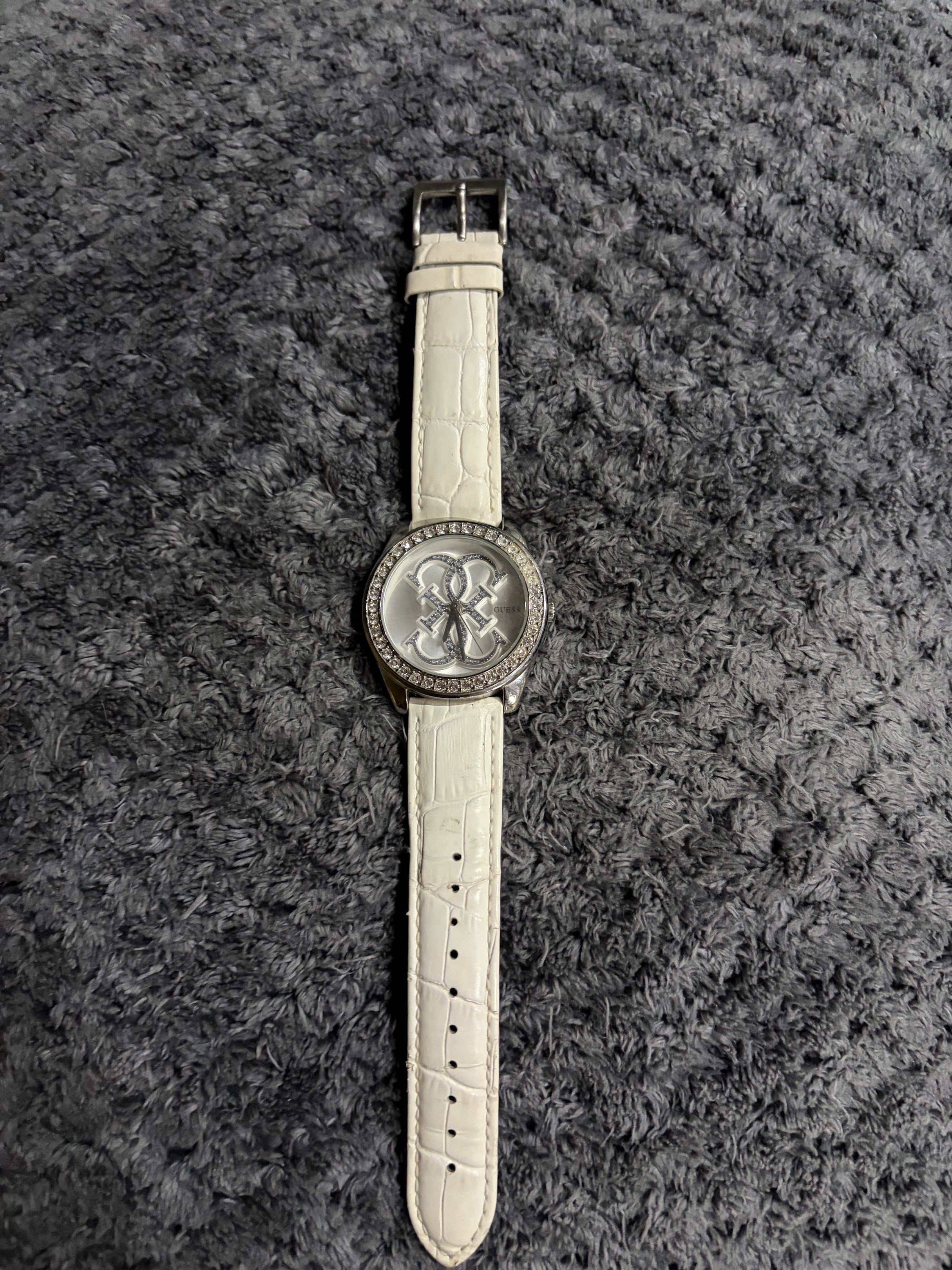 Original Guess White Watch with Rhinestones (Category: Women's Watches) located in Muntinlupa City. Submitted by violet1966 (Listing ID 1420198441, Image 1). Description: - Guess watch with white leather strap - Rhinestone-adorned watch face - Crocodile-patterned strap - Silver buckle - Stylish accessory.
